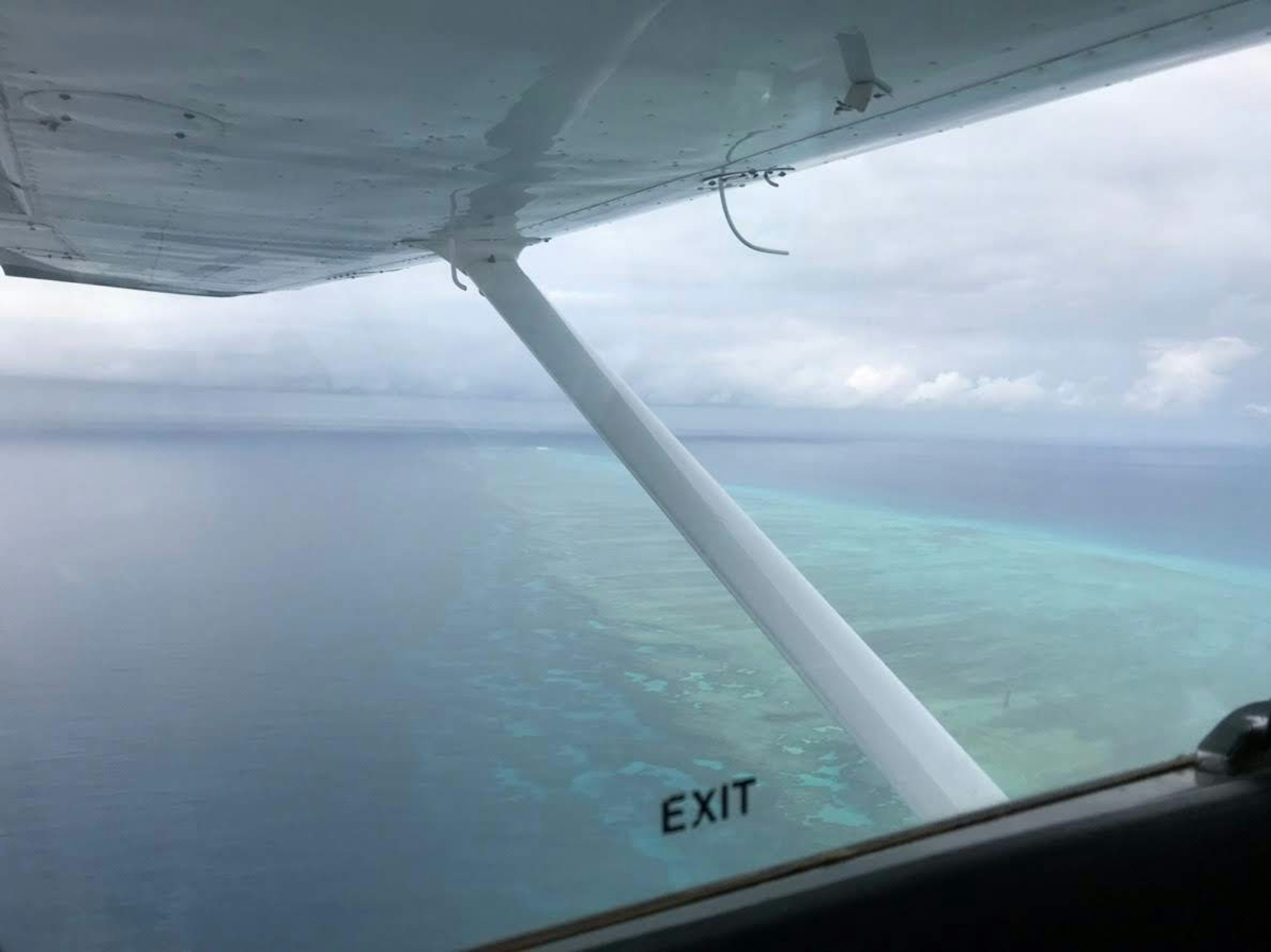 View from an airplane window showing the ocean and sky