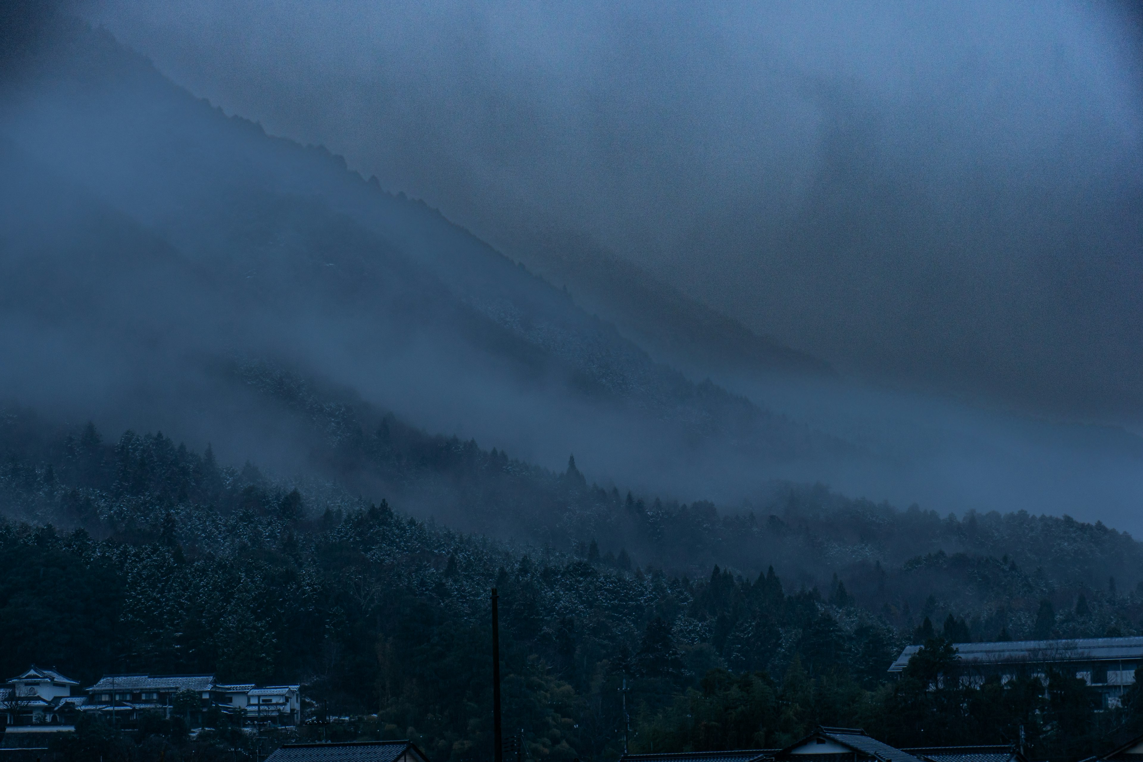 Misty blue mountain landscape with houses