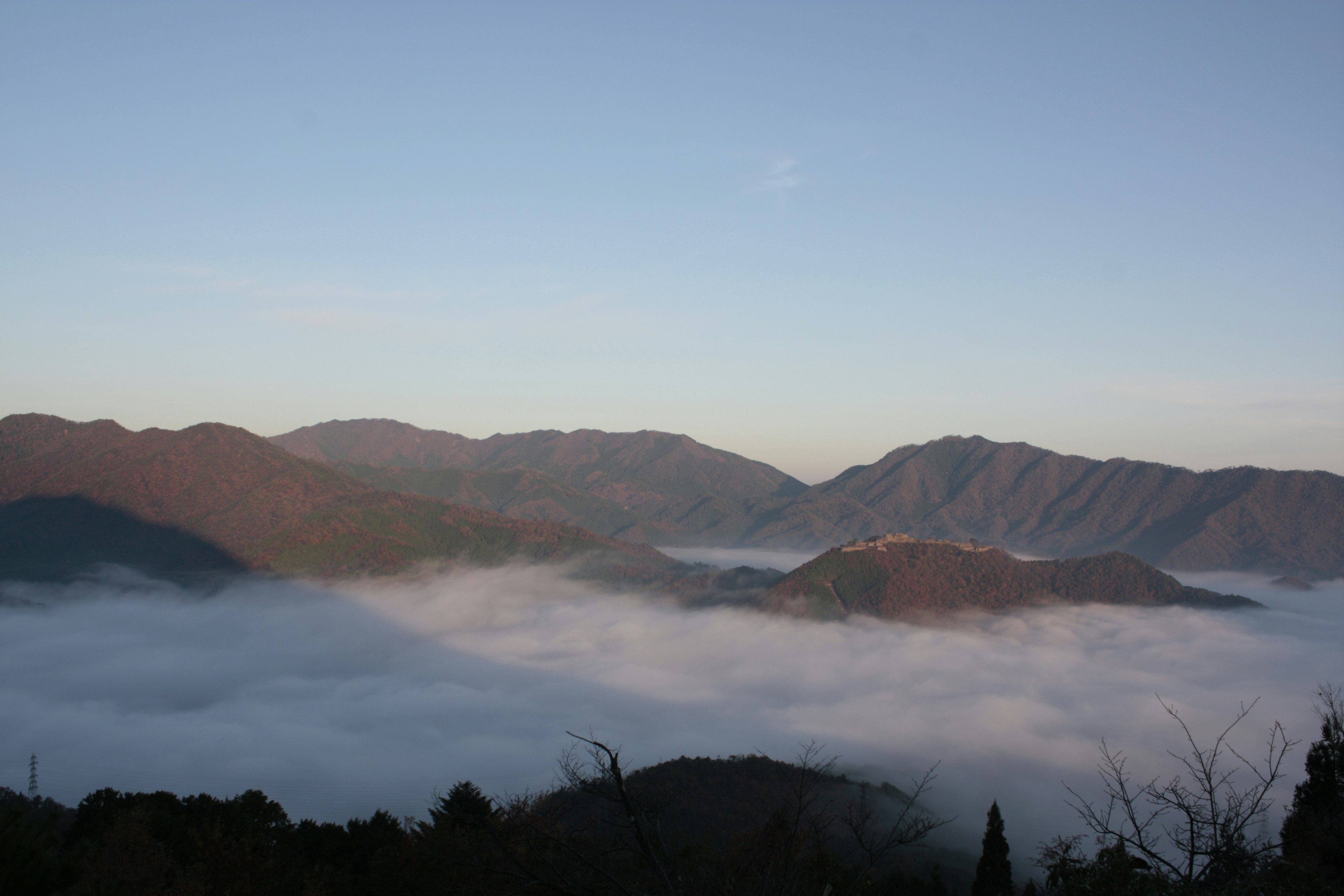 Pemandangan pegunungan dengan lautan awan saat fajar