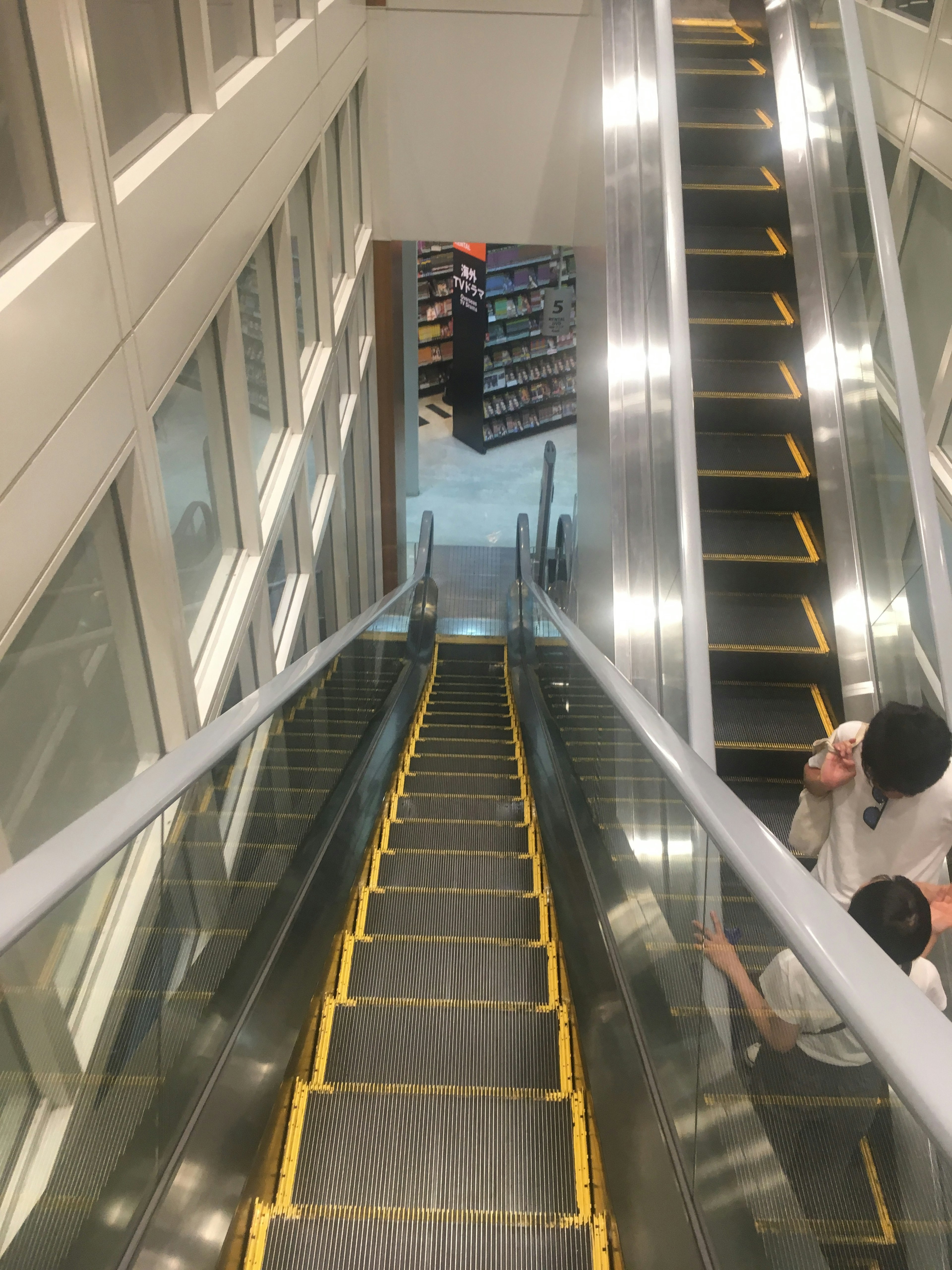 Interior view of a commercial space with stairs and escalators