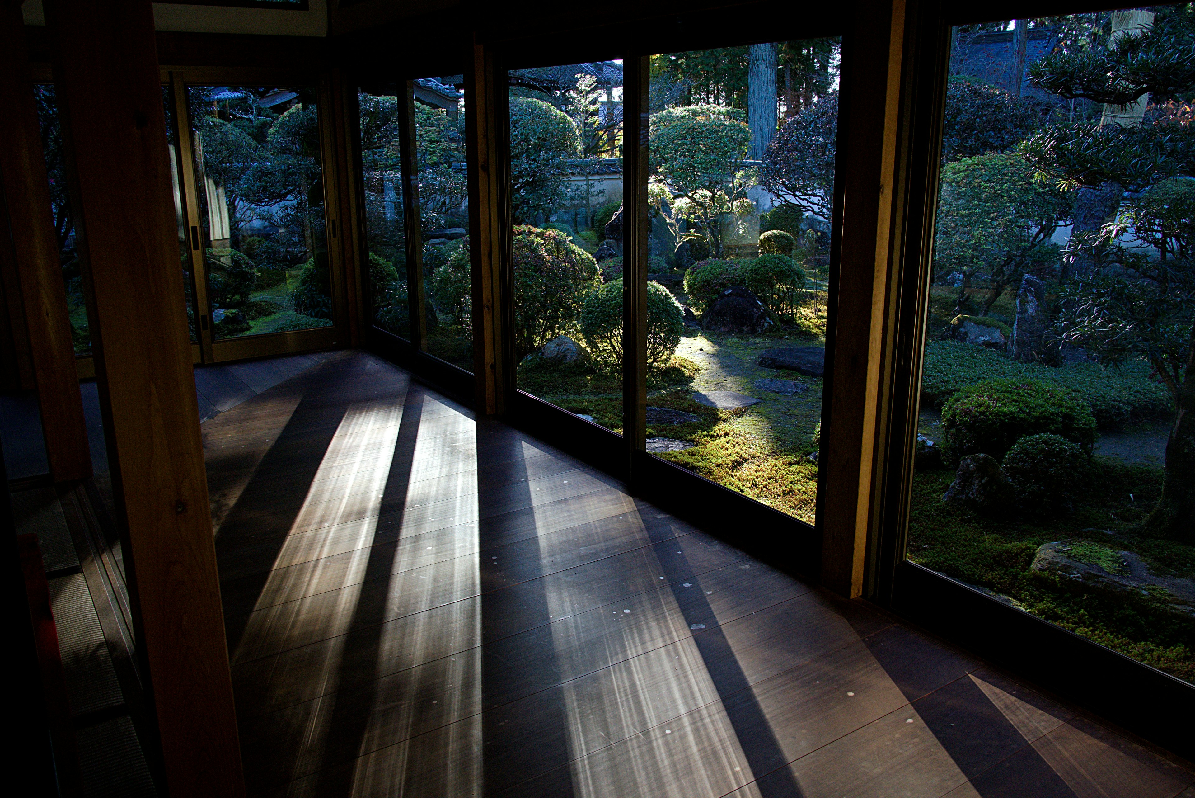 Innenansicht mit Blick auf einen ruhigen japanischen Garten sanftes Licht von den Fenstern