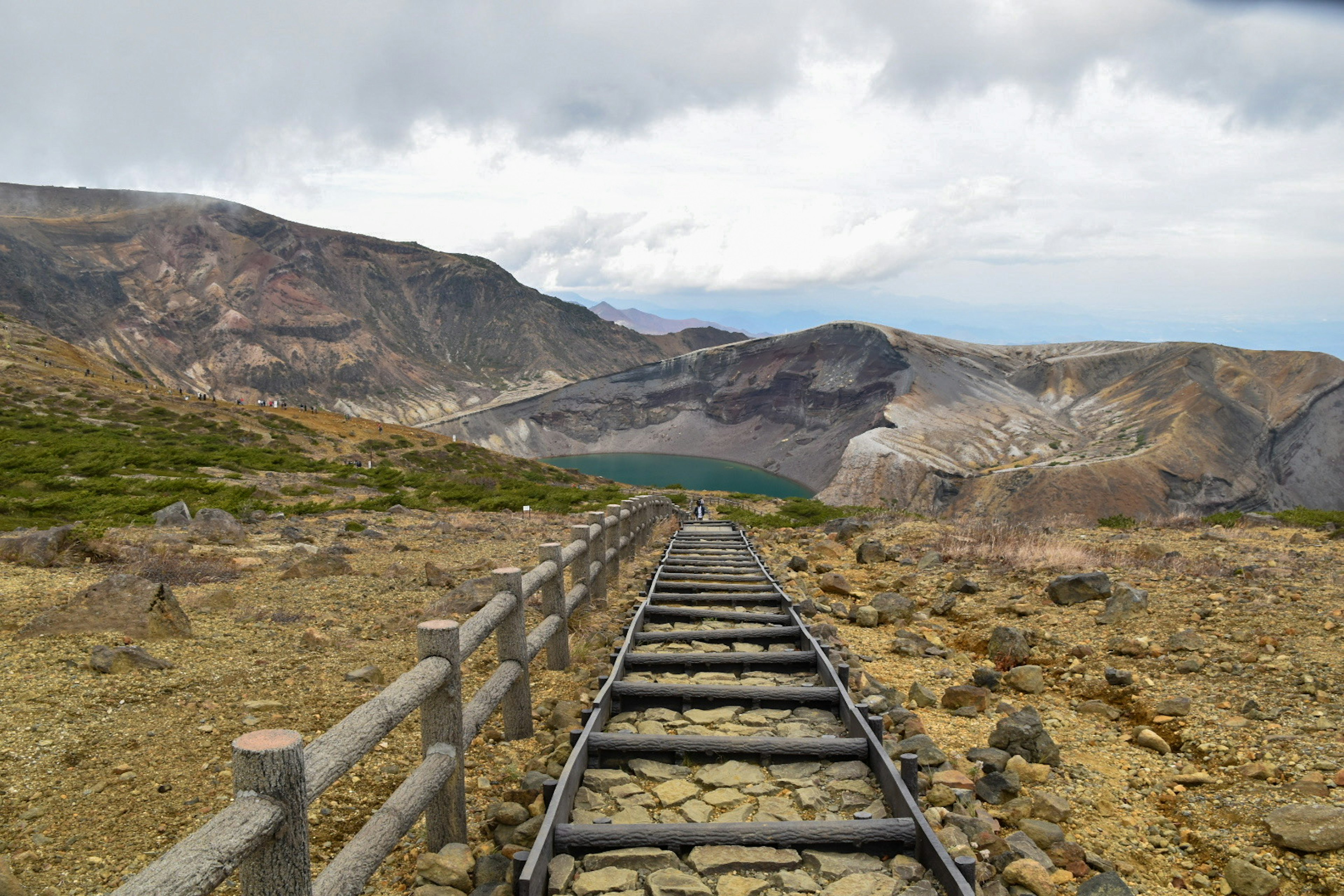 Viejas vías de tren que conducen a un paisaje montañoso con un lago