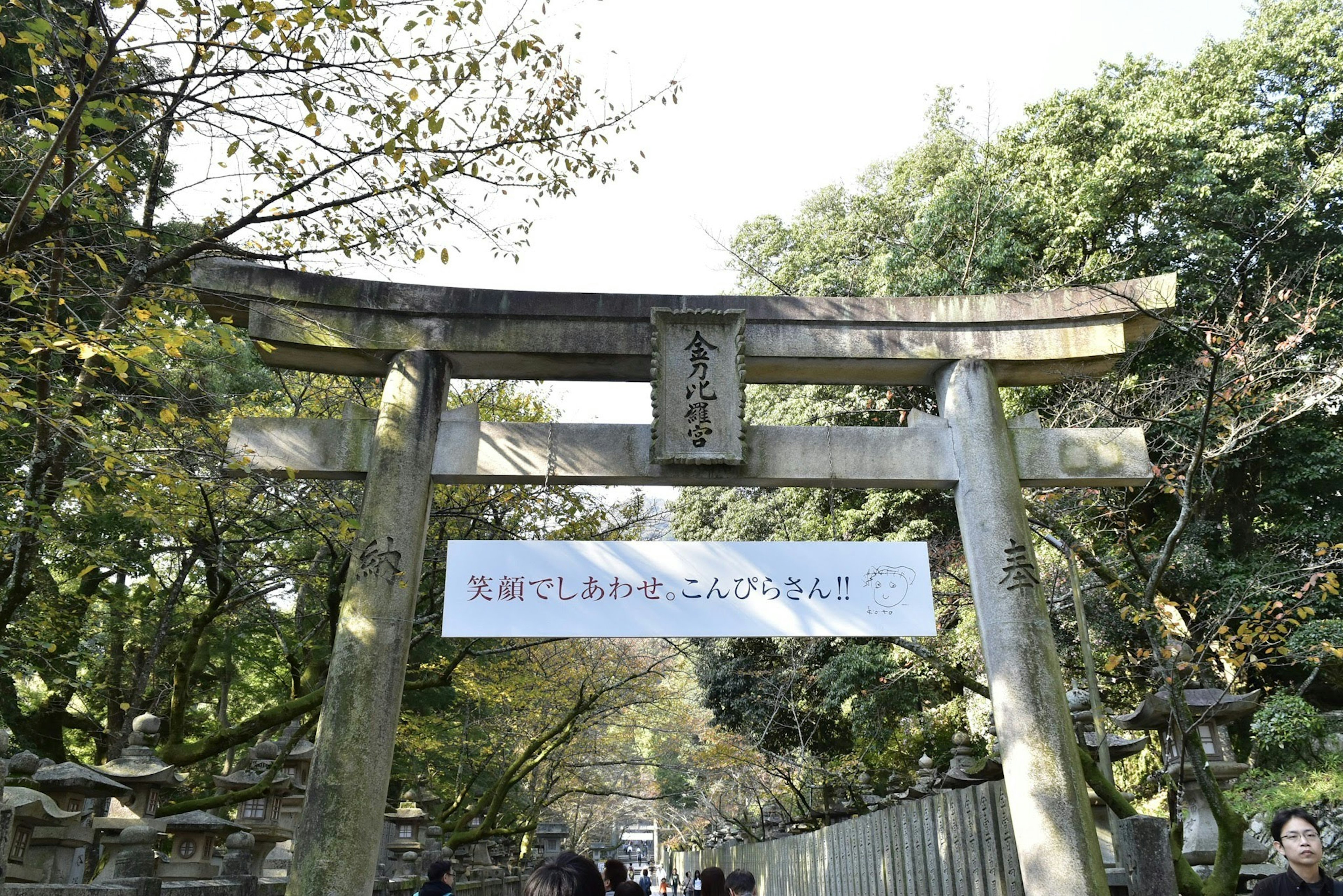 Gerbang torii dengan papan nama dan latar belakang hijau subur