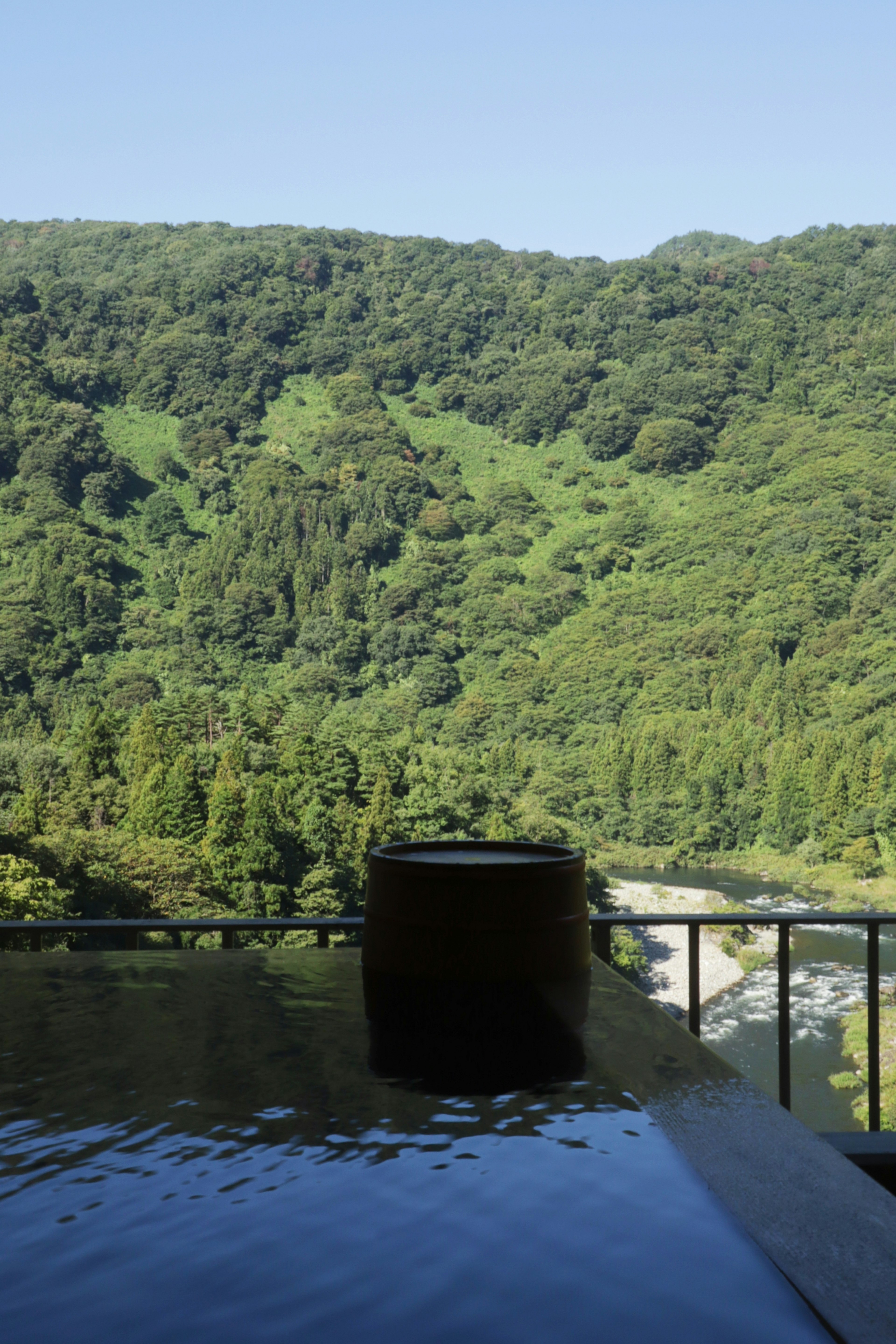 Vue panoramique d'une source chaude avec des montagnes verdoyantes en arrière-plan