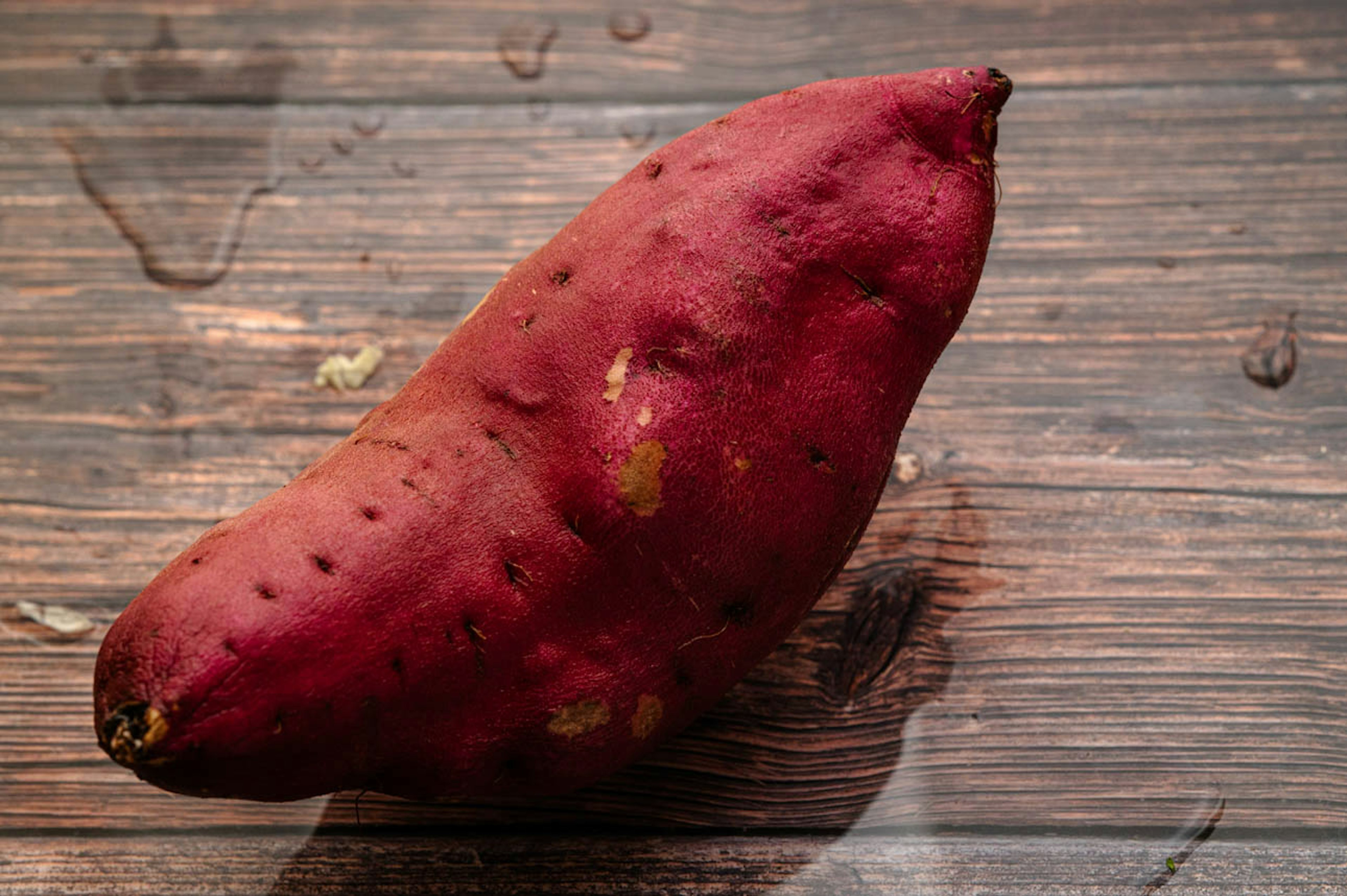 A red sweet potato placed on a wooden table