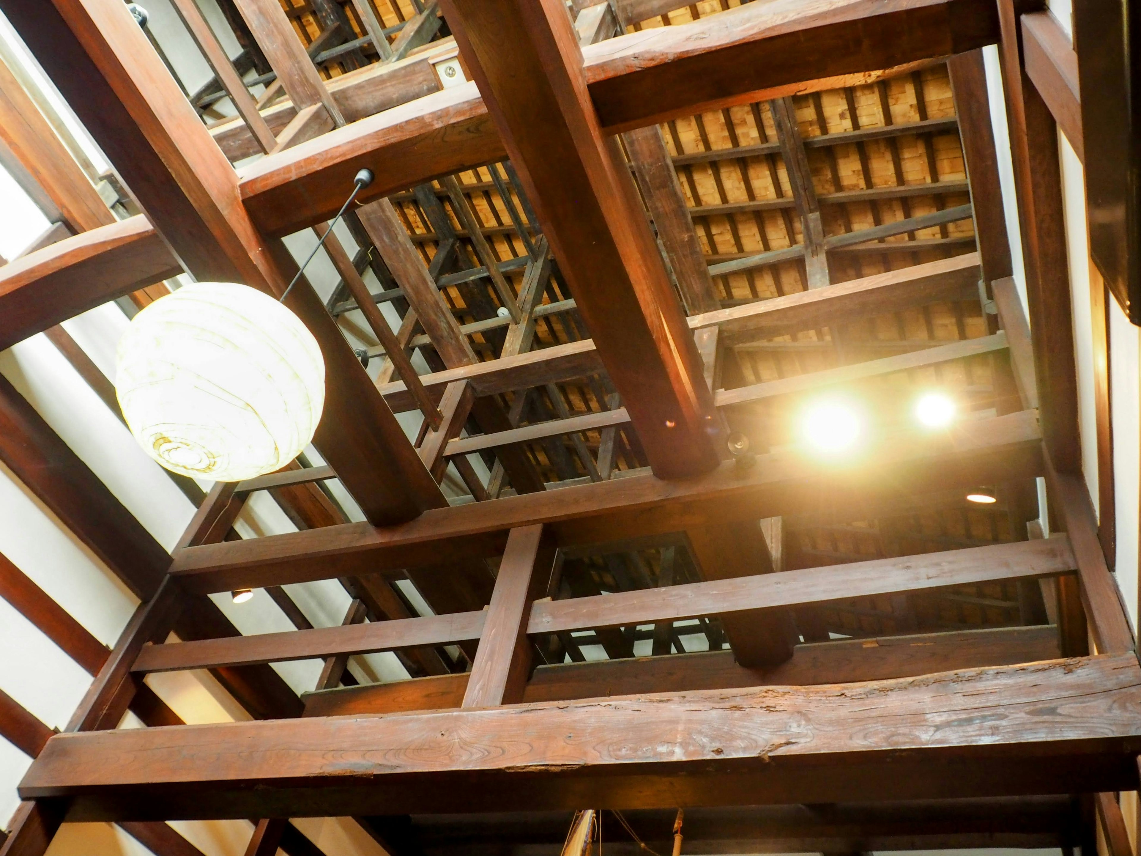 Techo de una arquitectura japonesa tradicional con vigas de madera y luces