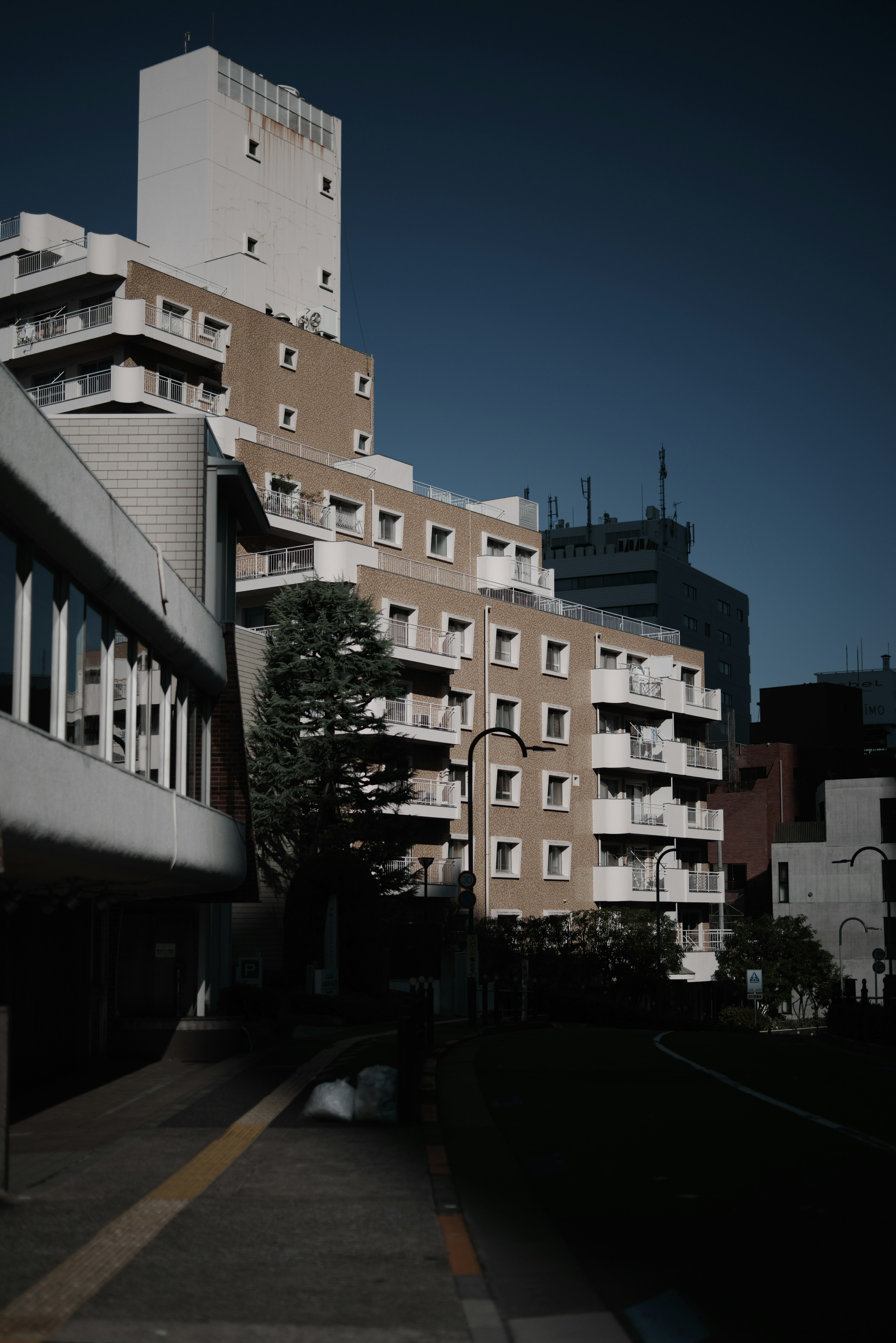 Urban landscape featuring a tall building and a low-rise apartment complex