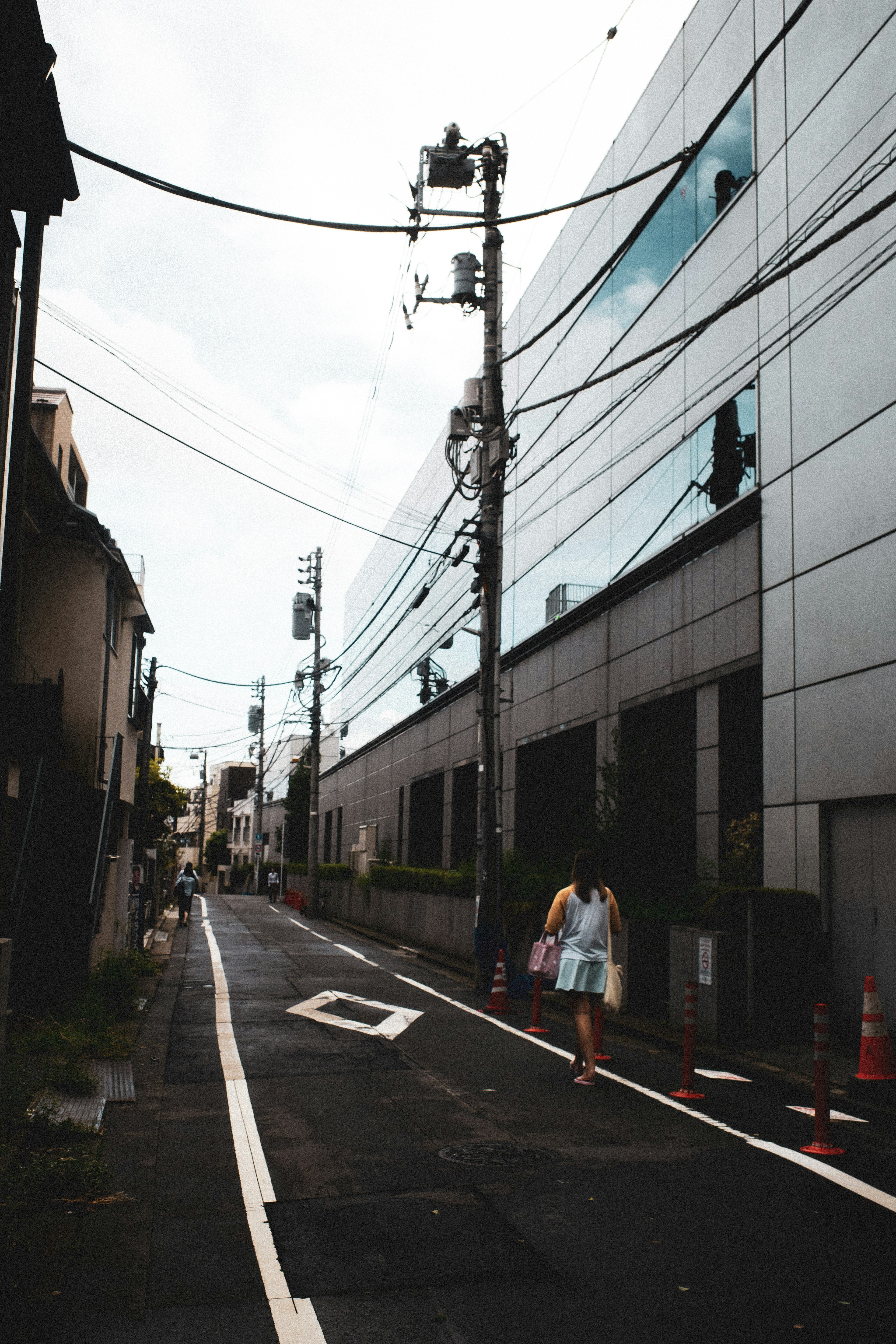 都市の通りに沿った近代的な建物と電線の風景