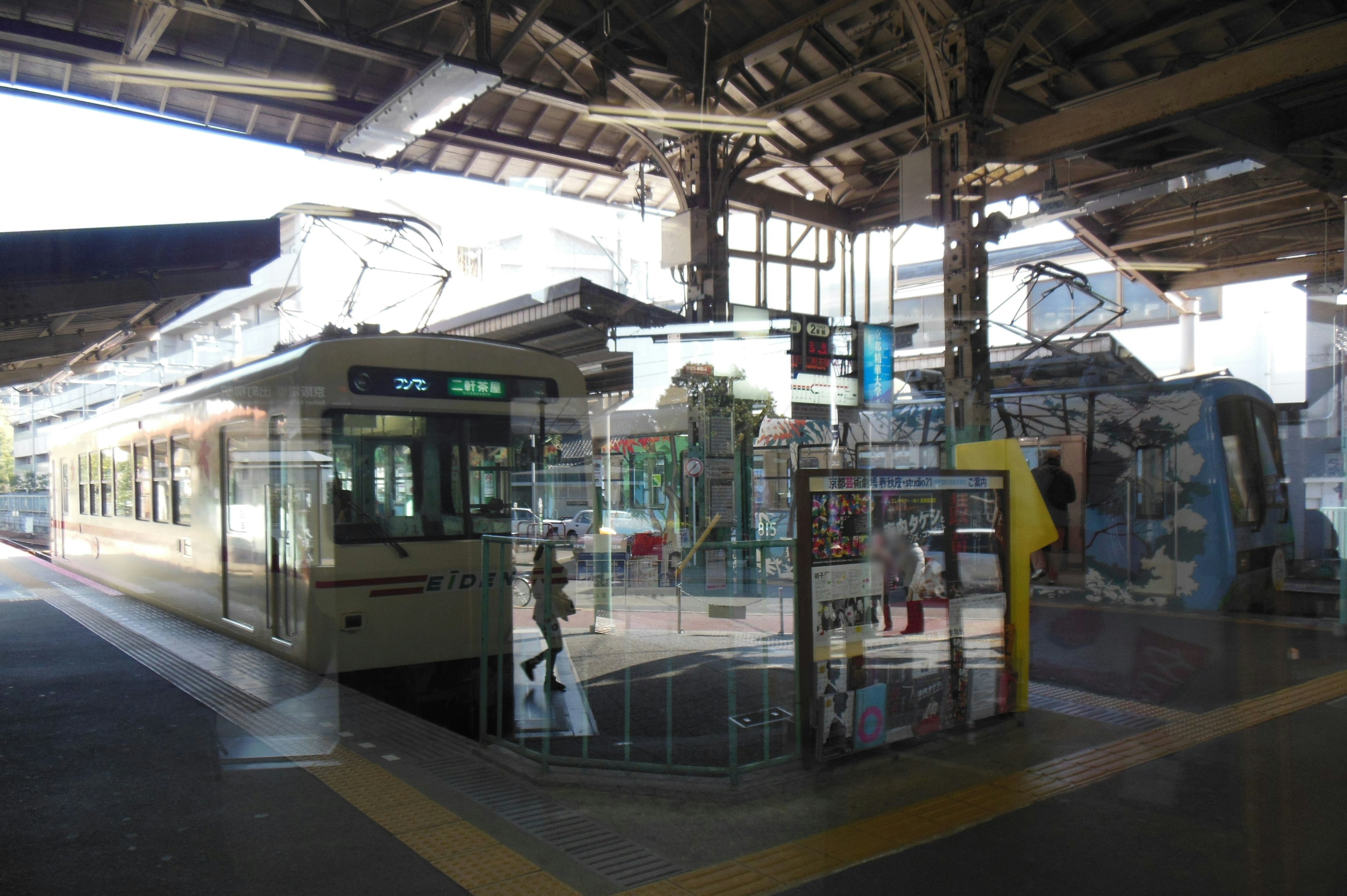 駅のプラットフォームに停車中のトラムと乗客