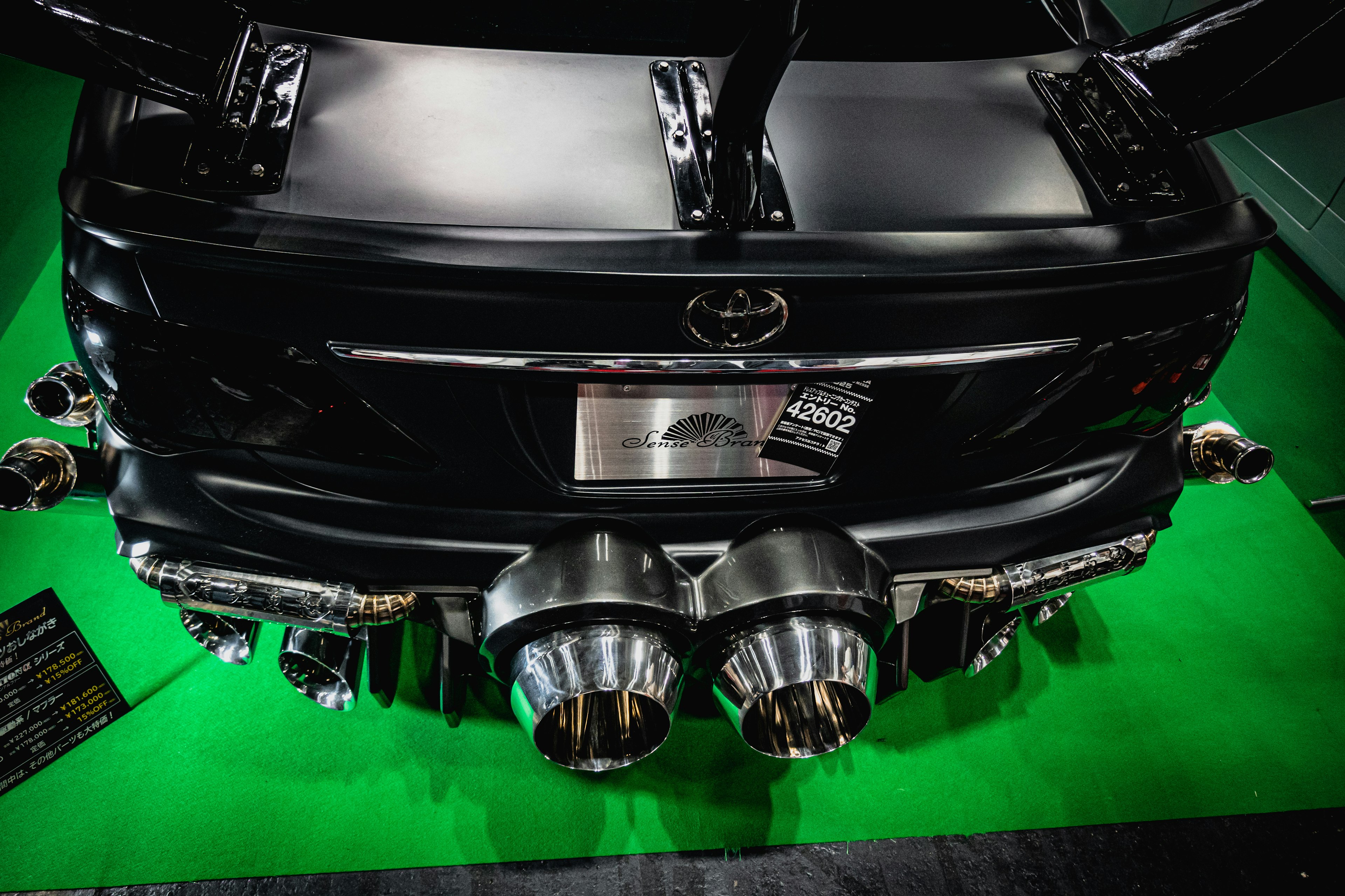 Rear view of a black Toyota car with custom exhaust pipes