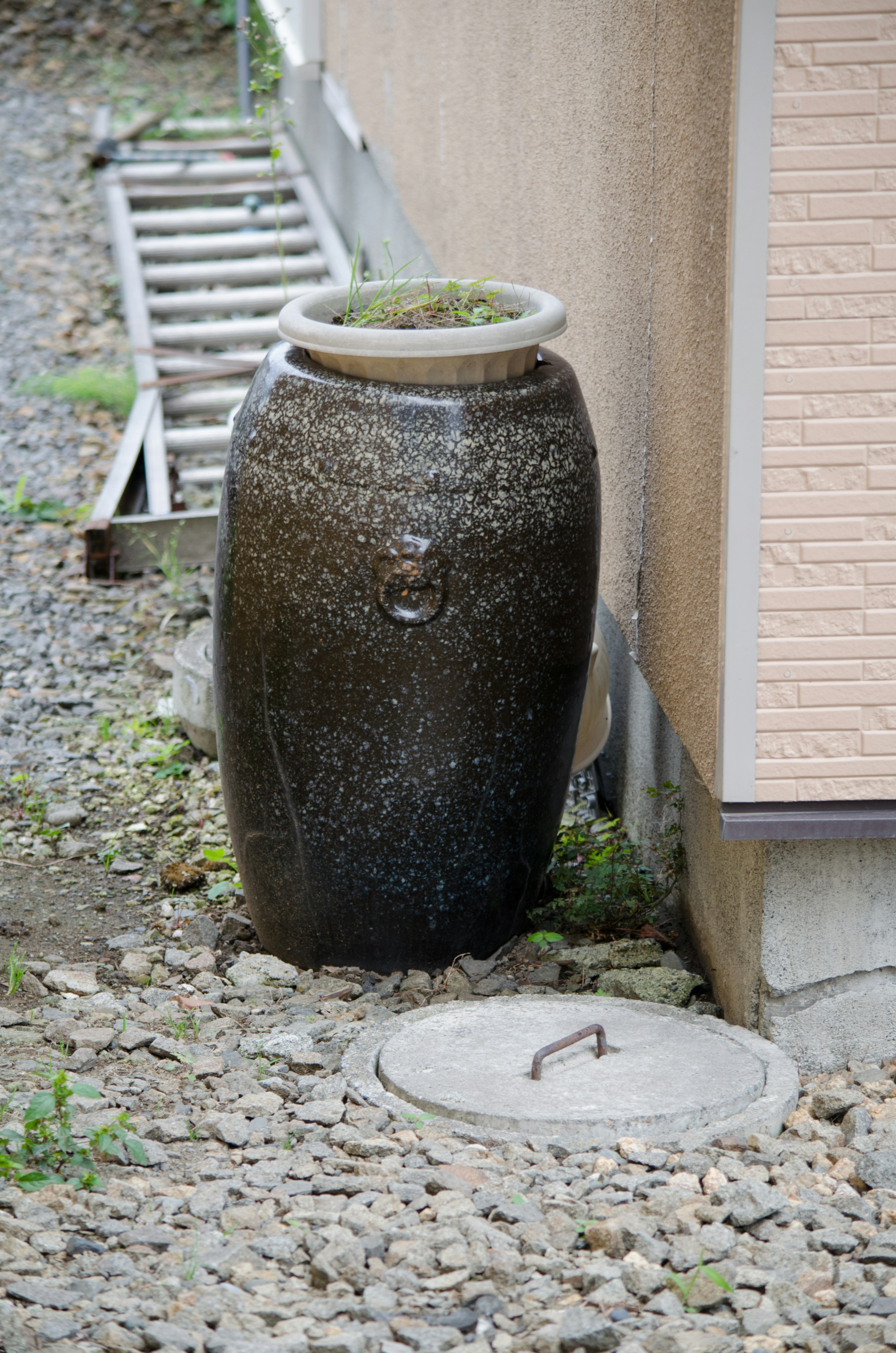 美しい黒い陶器の水壺が壁の近くに置かれている