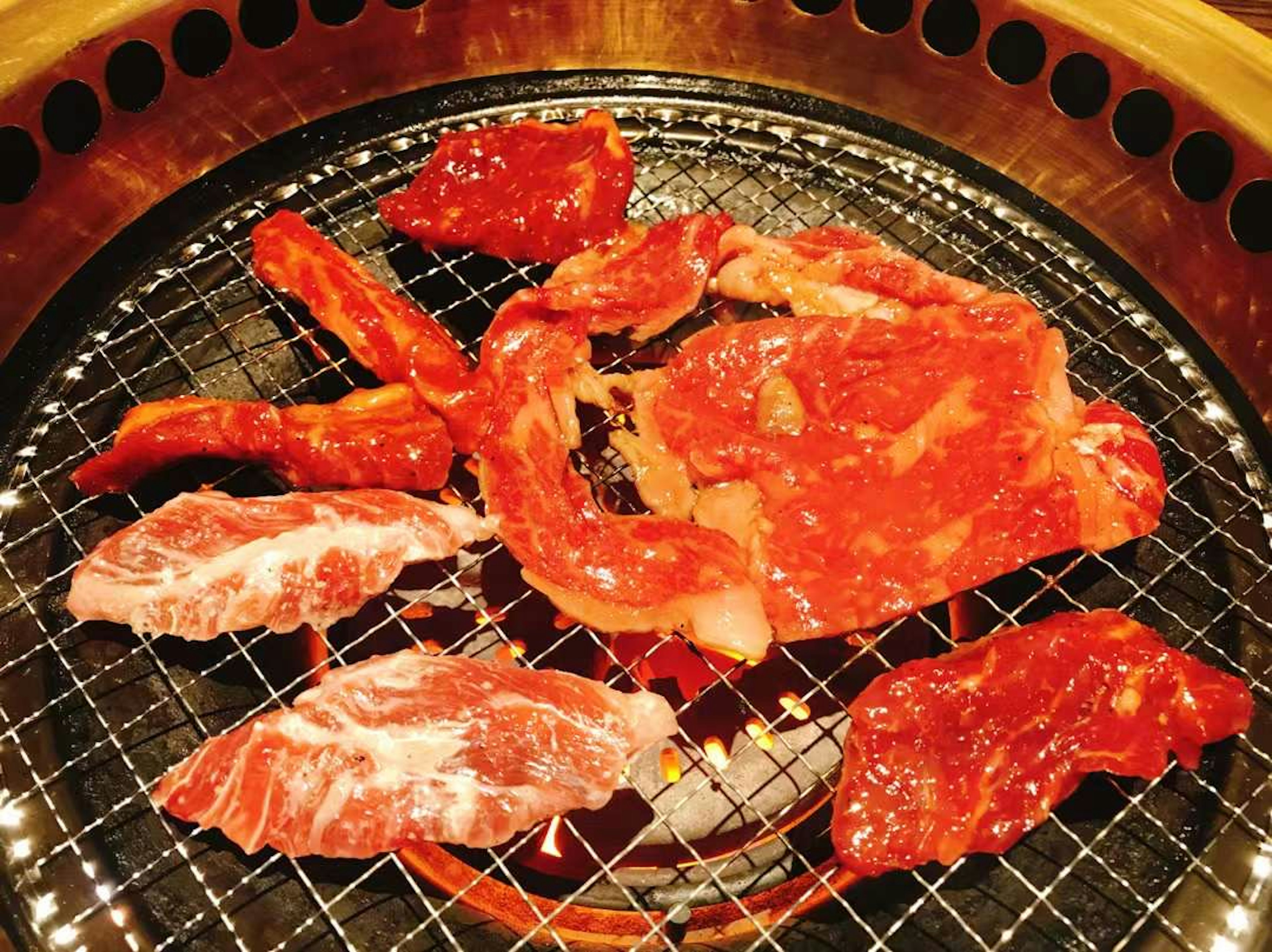 Rebanadas de carne fresca en una parrilla para yakiniku