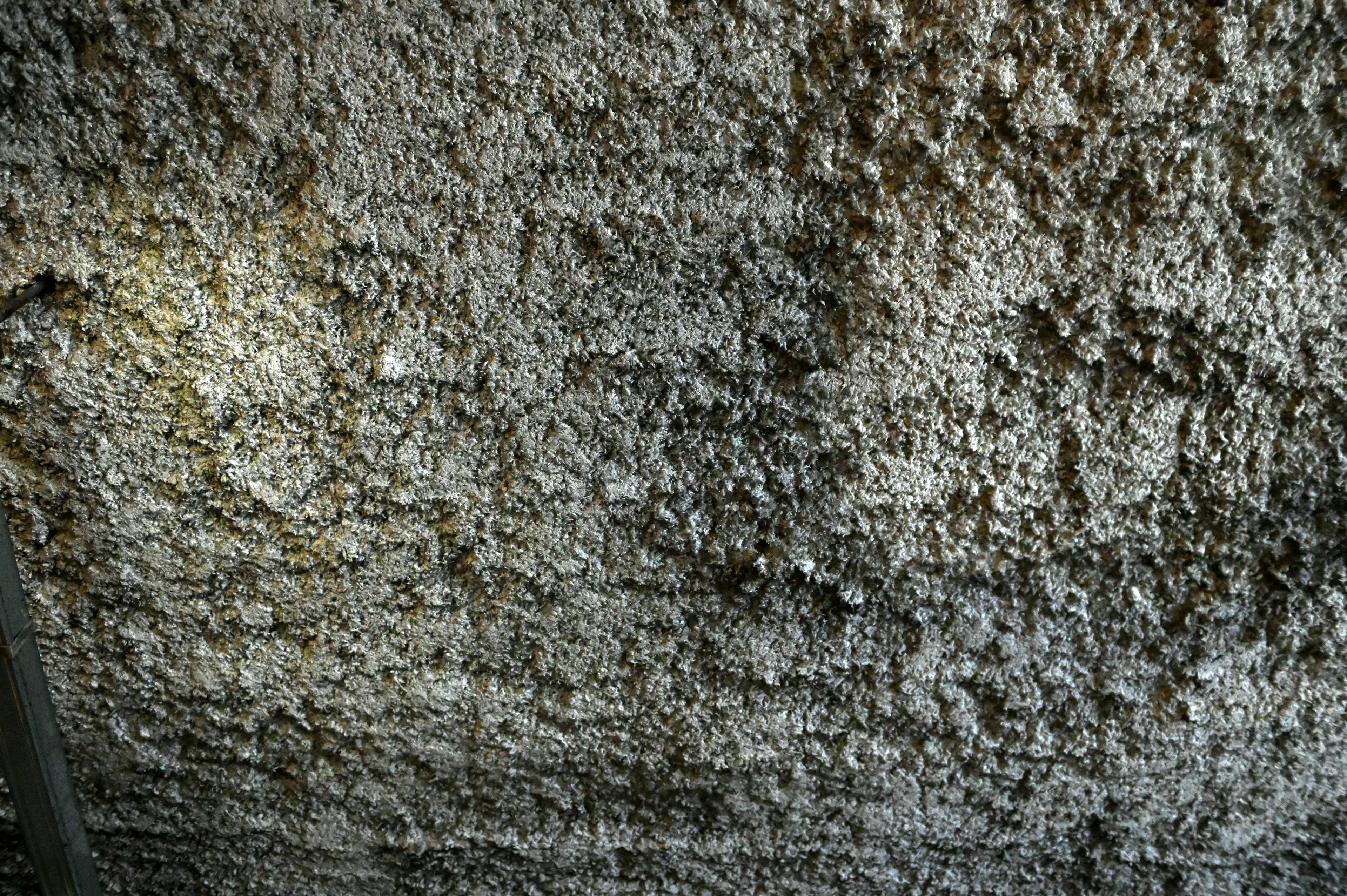 Image d'un plafond texturé avec une surface rugueuse présentant des couleurs claires et des ombres