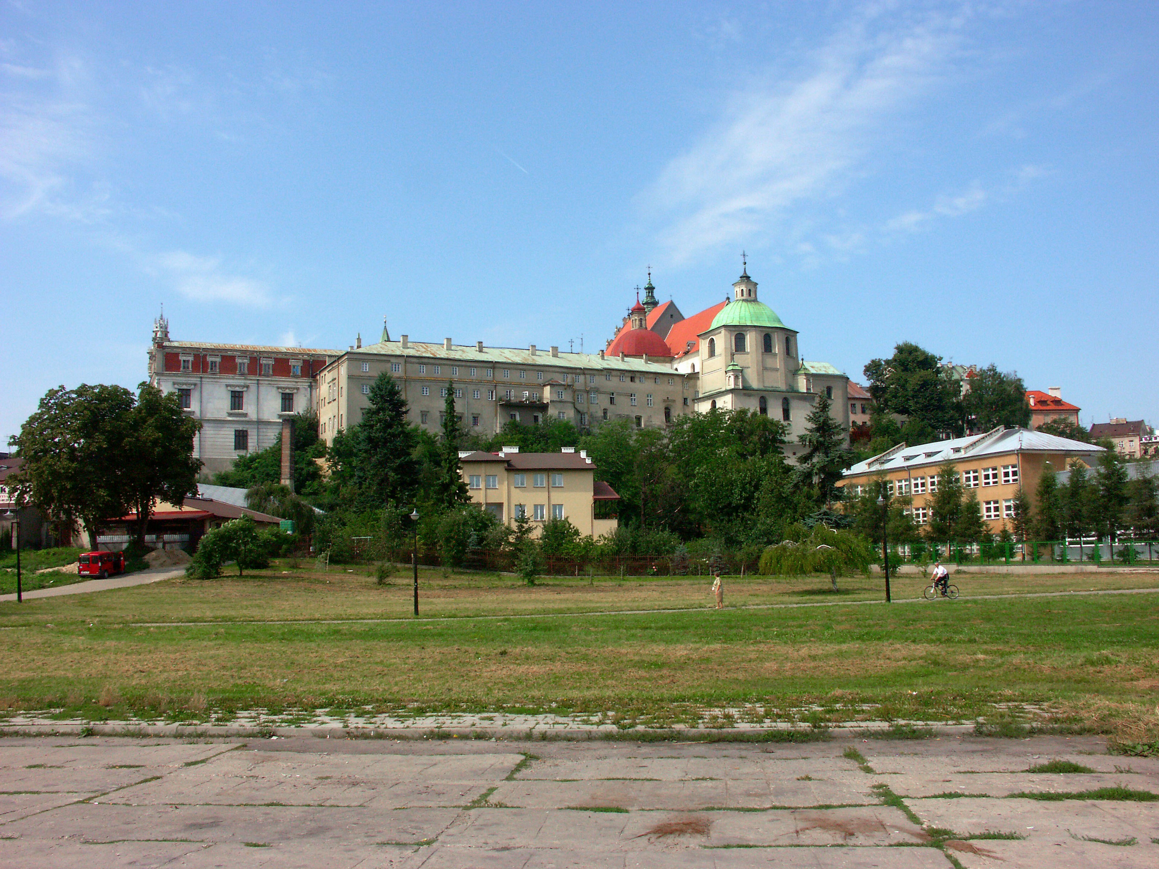 Complexe de bâtiments historiques avec des toits colorés près d'un parc verdoyant