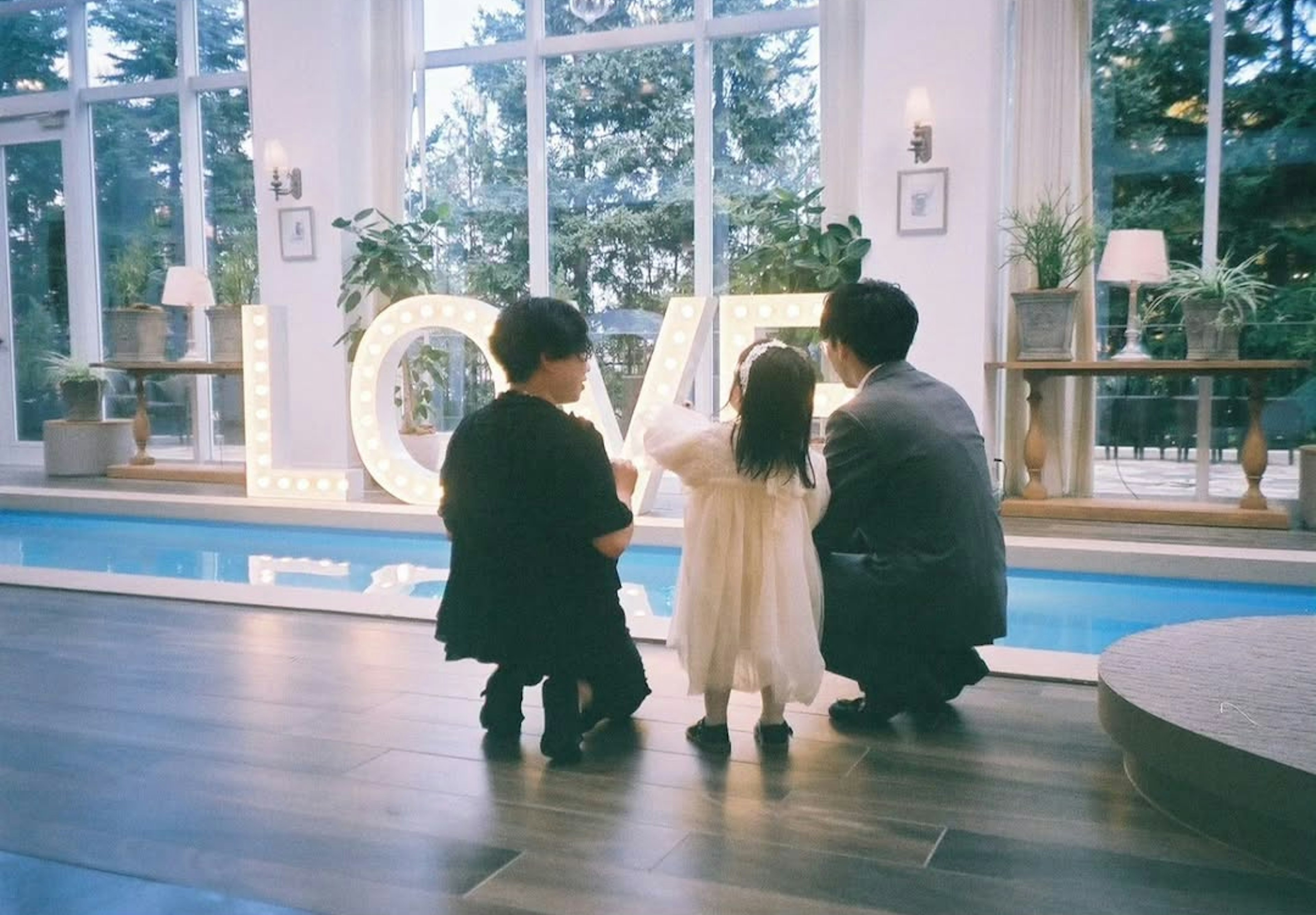 A family standing in front of a large illuminated LOVE sign