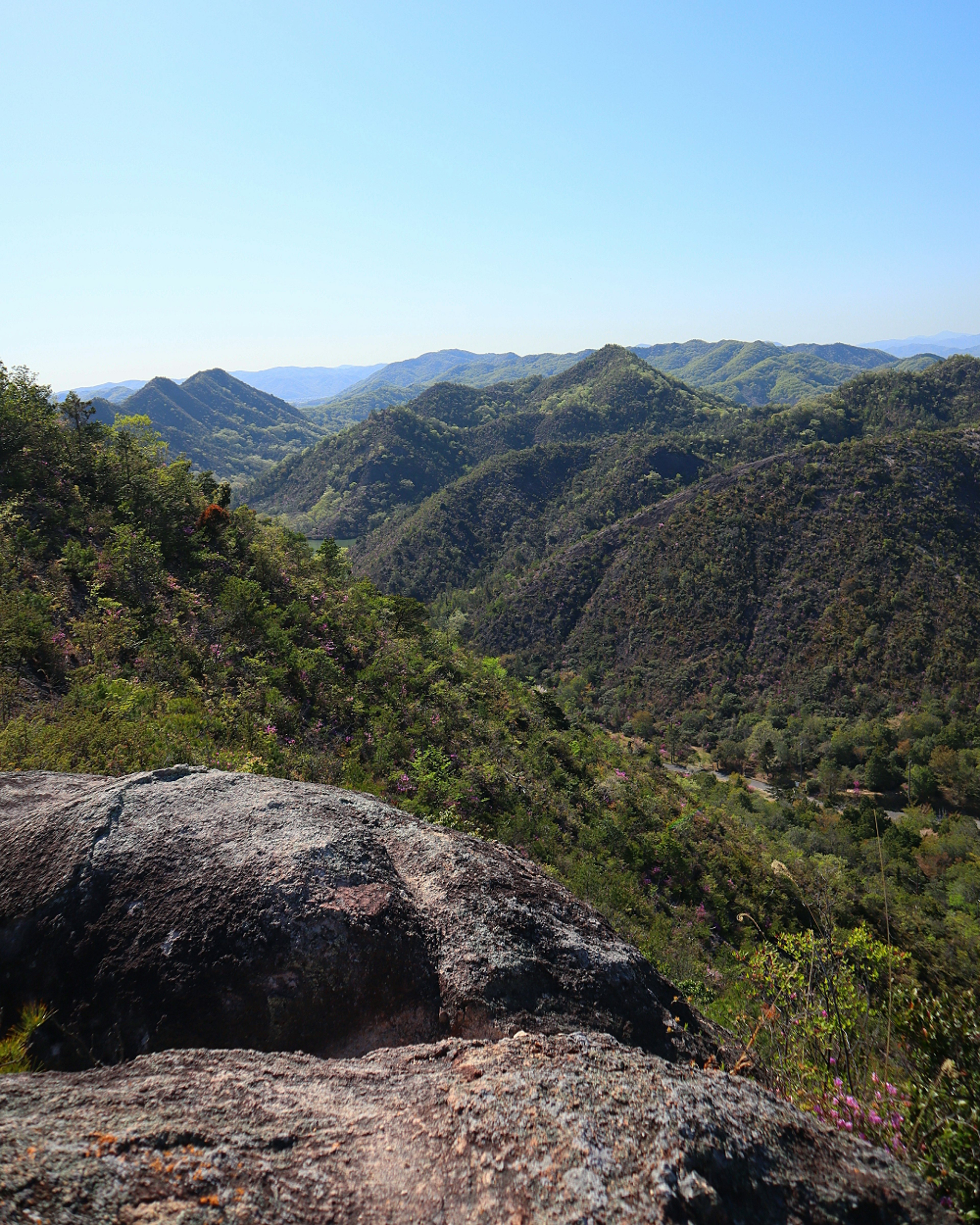 Paisaje montañoso verde bajo un cielo azul claro