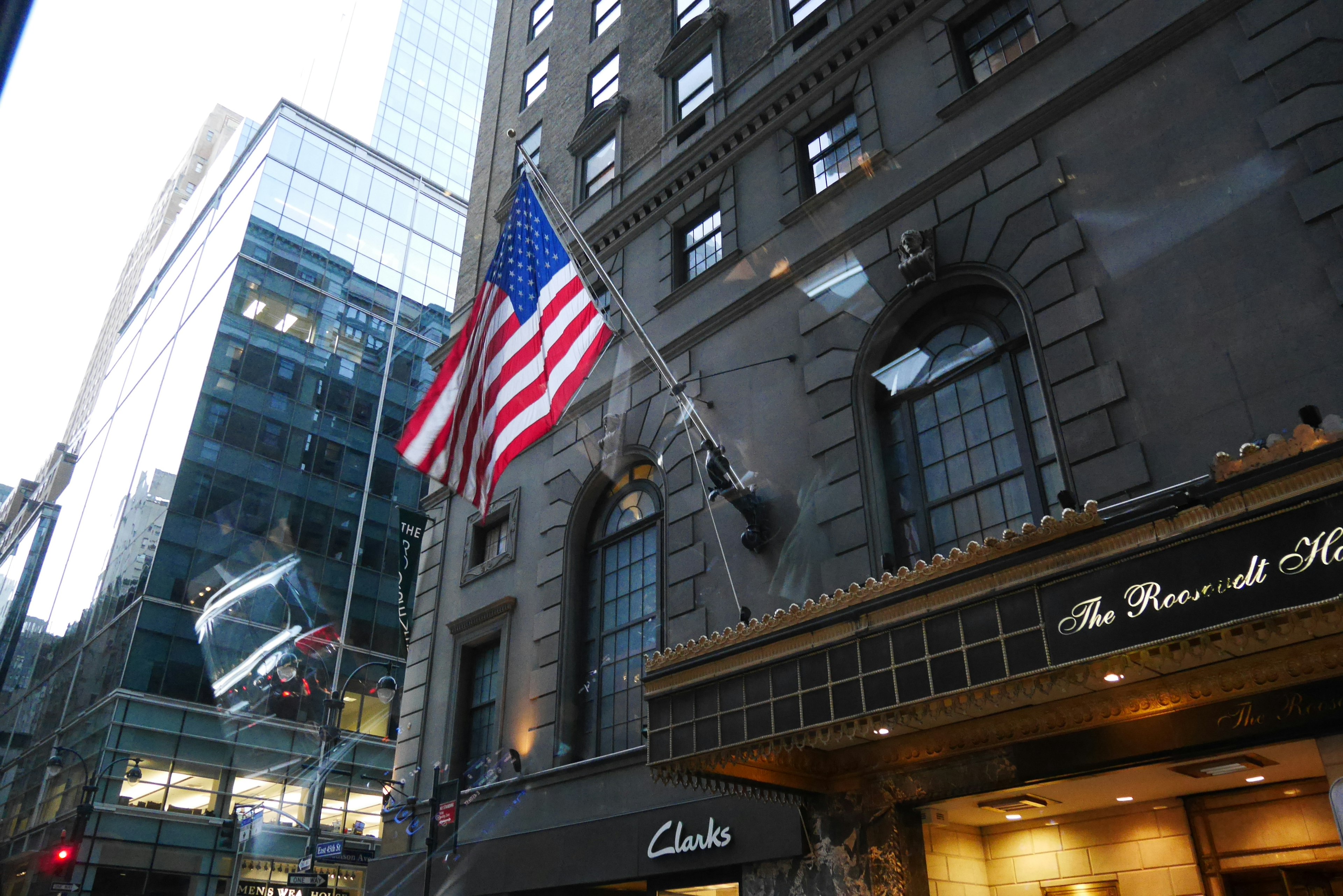 Edificio storico con bandiera americana e grattacieli moderni nello skyline