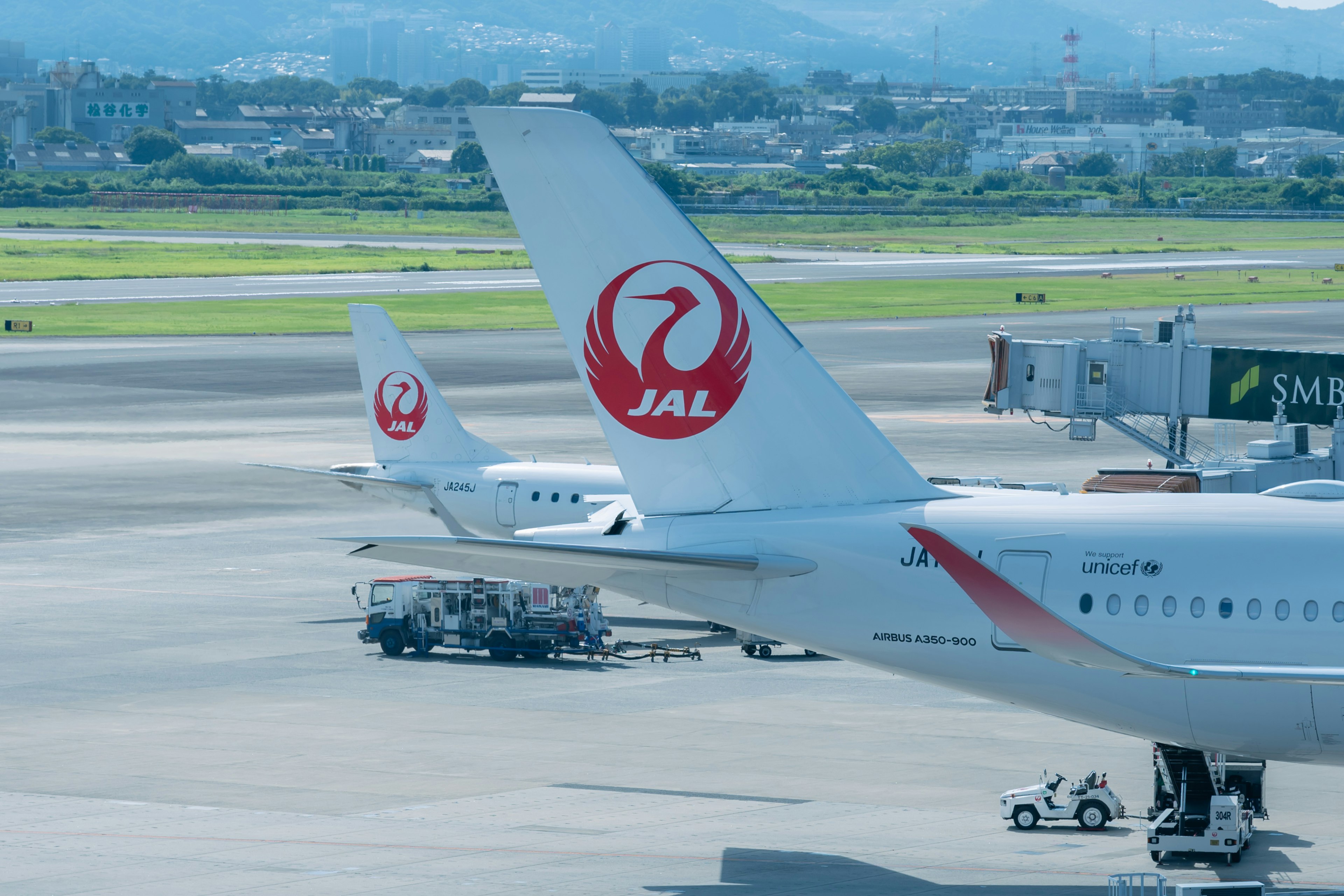 空港の滑走路に停まっている日本航空の飛行機の尾翼