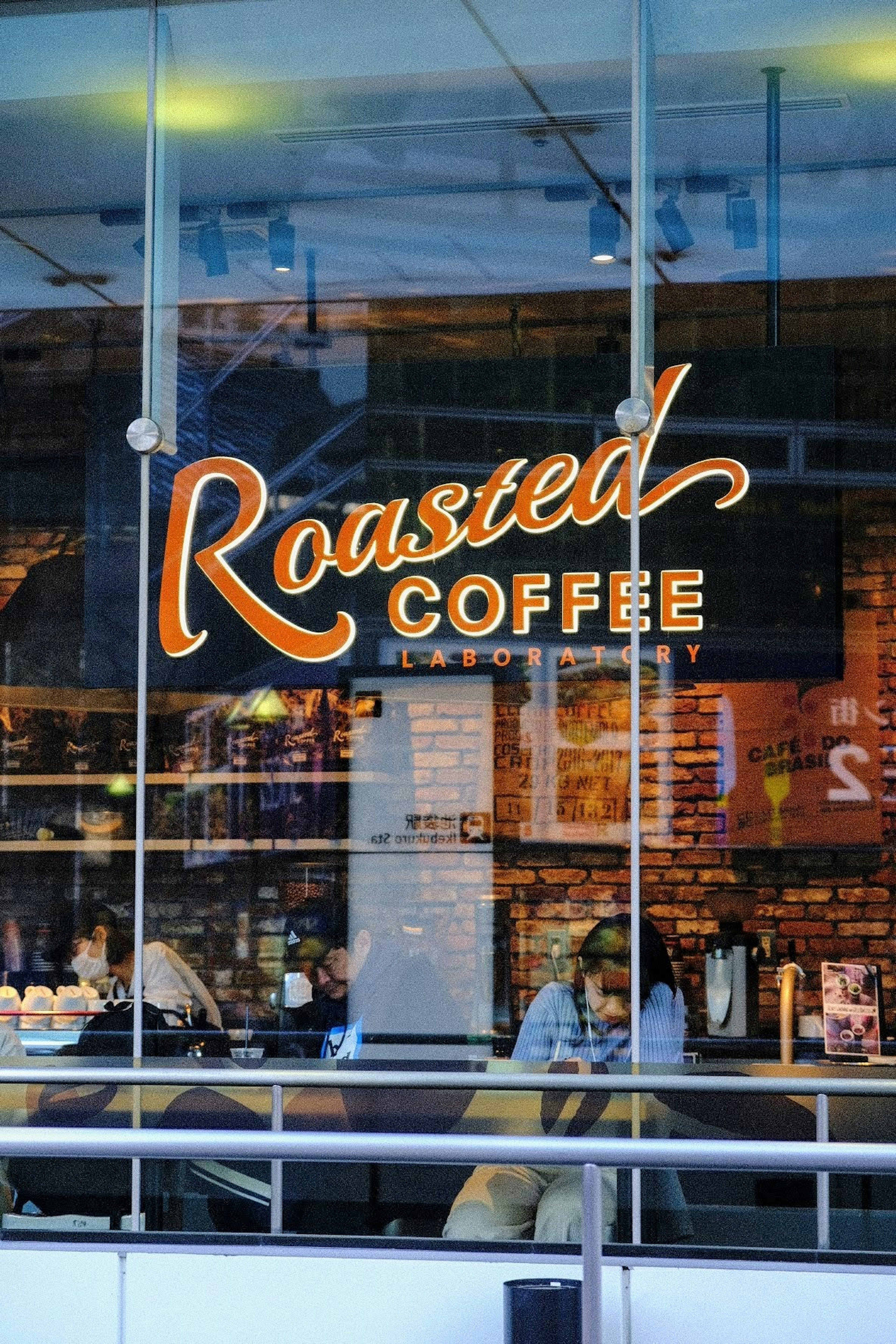 ฉากหน้าต่างของคาเฟ่ที่มีป้าย Roasted Coffee