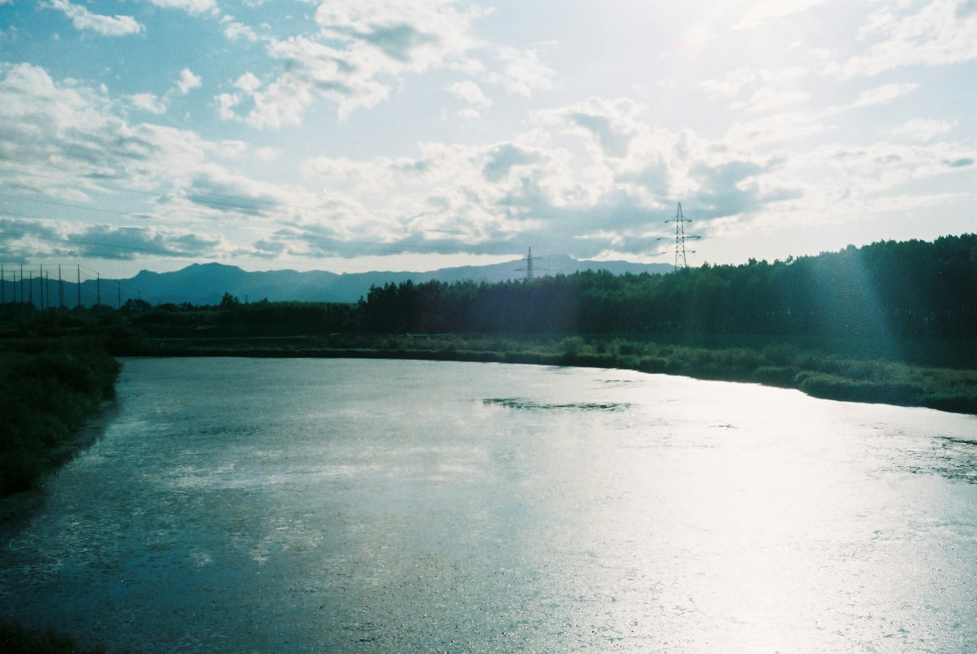 Gambar yang menggambarkan pemandangan sungai tenang dan langit biru