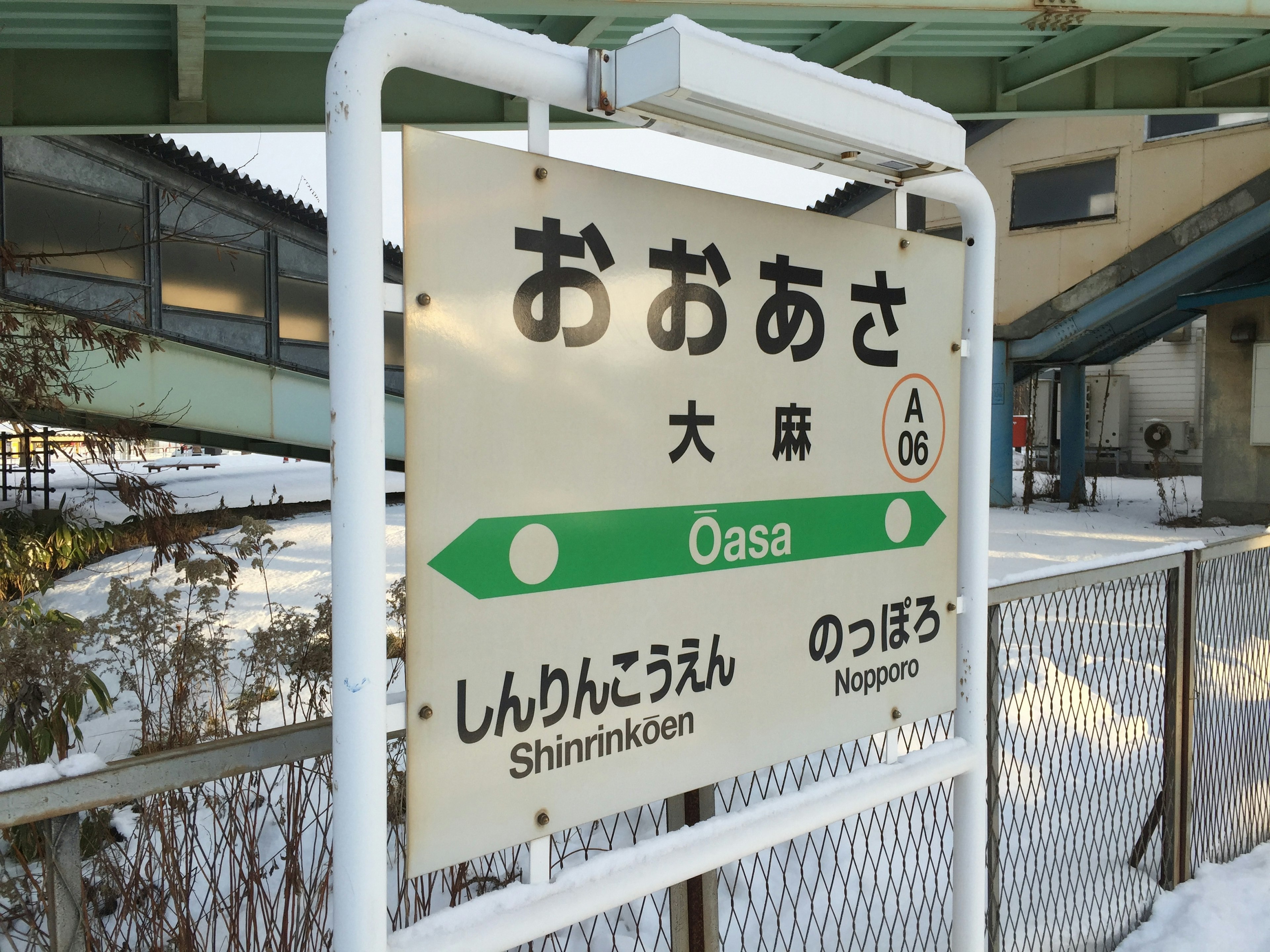 Oasa Station sign with snow-covered surroundings