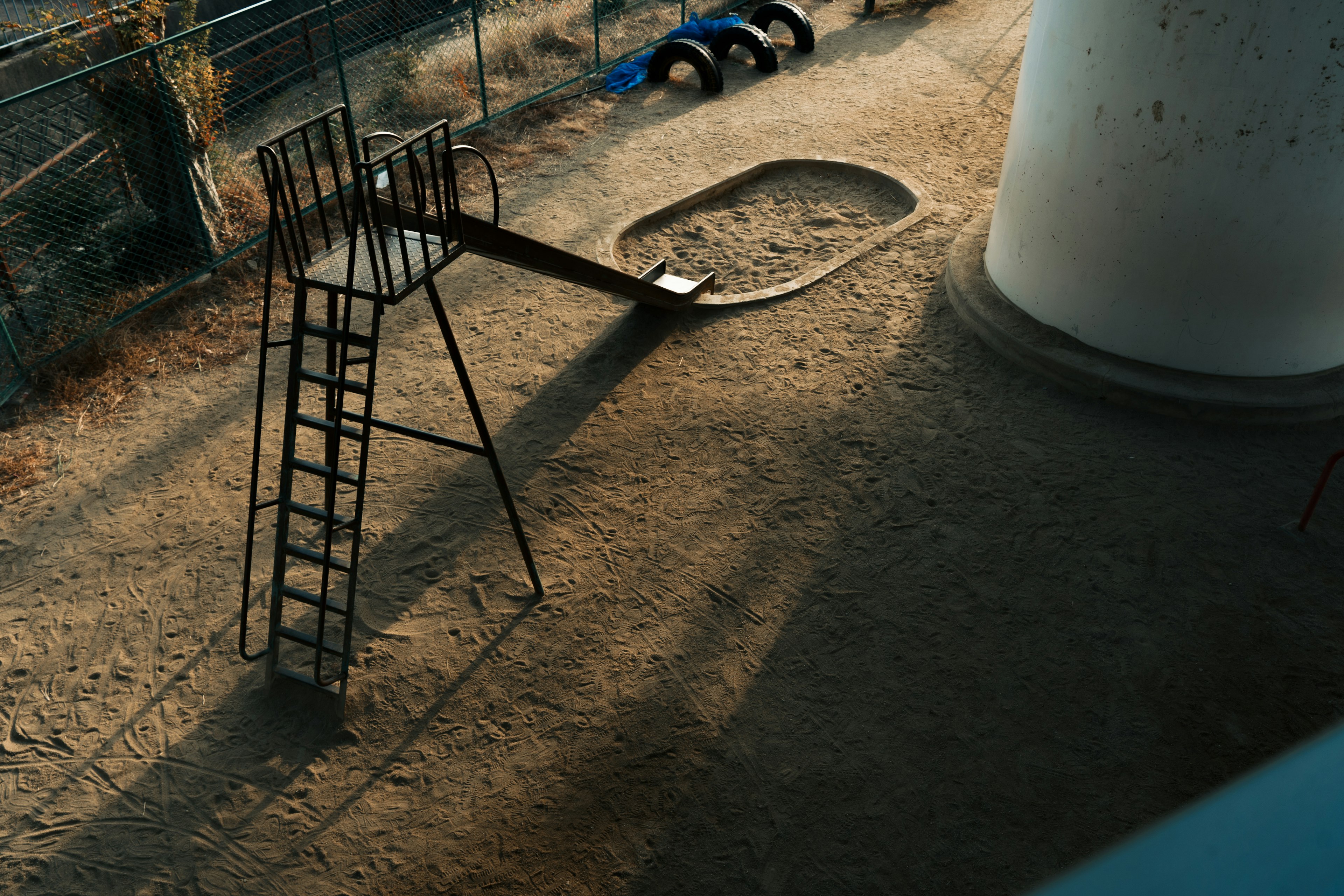 Abandoned playground featuring a slide and a sandbox