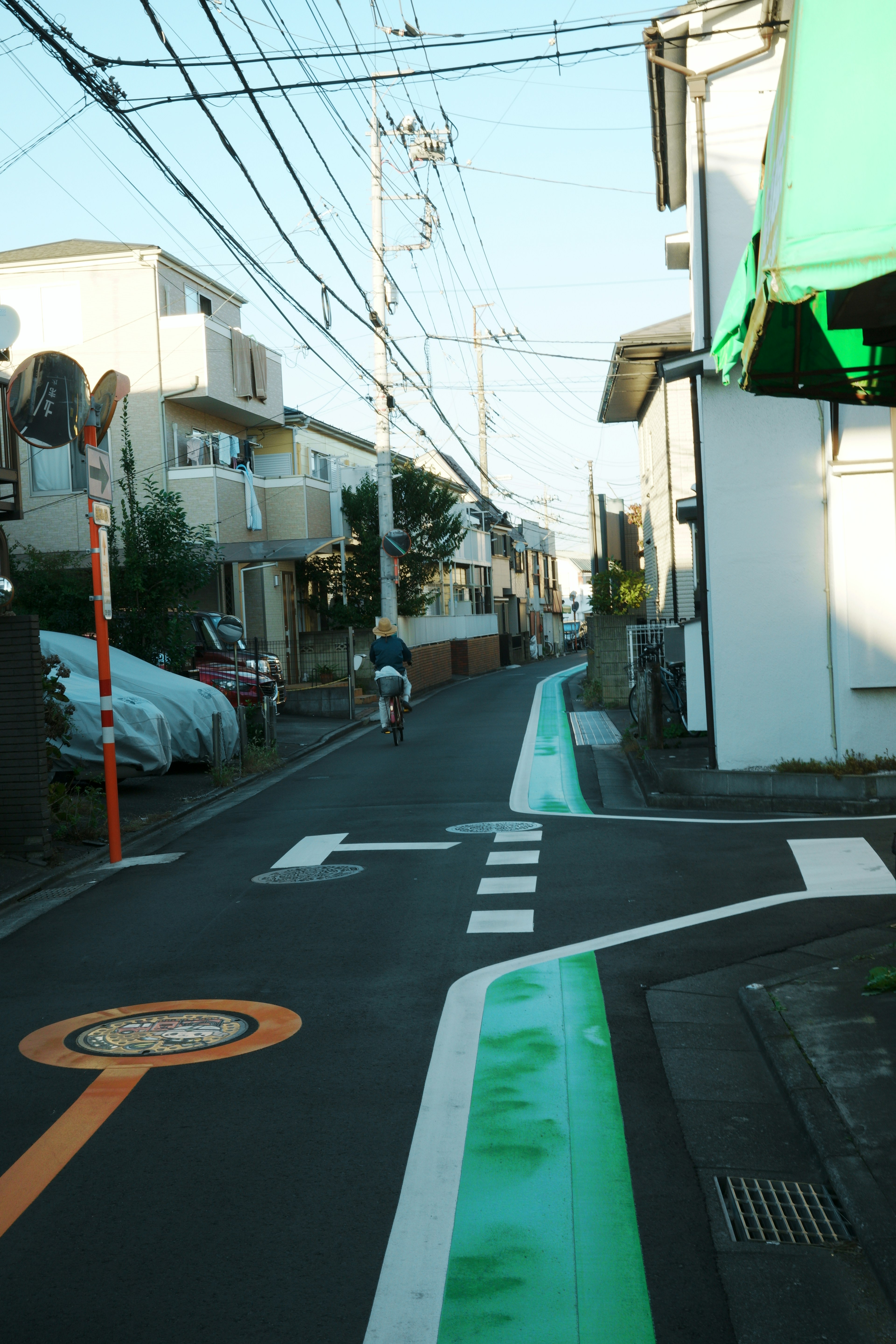 狭い通りに沿った住宅と青空を背景にした街の風景