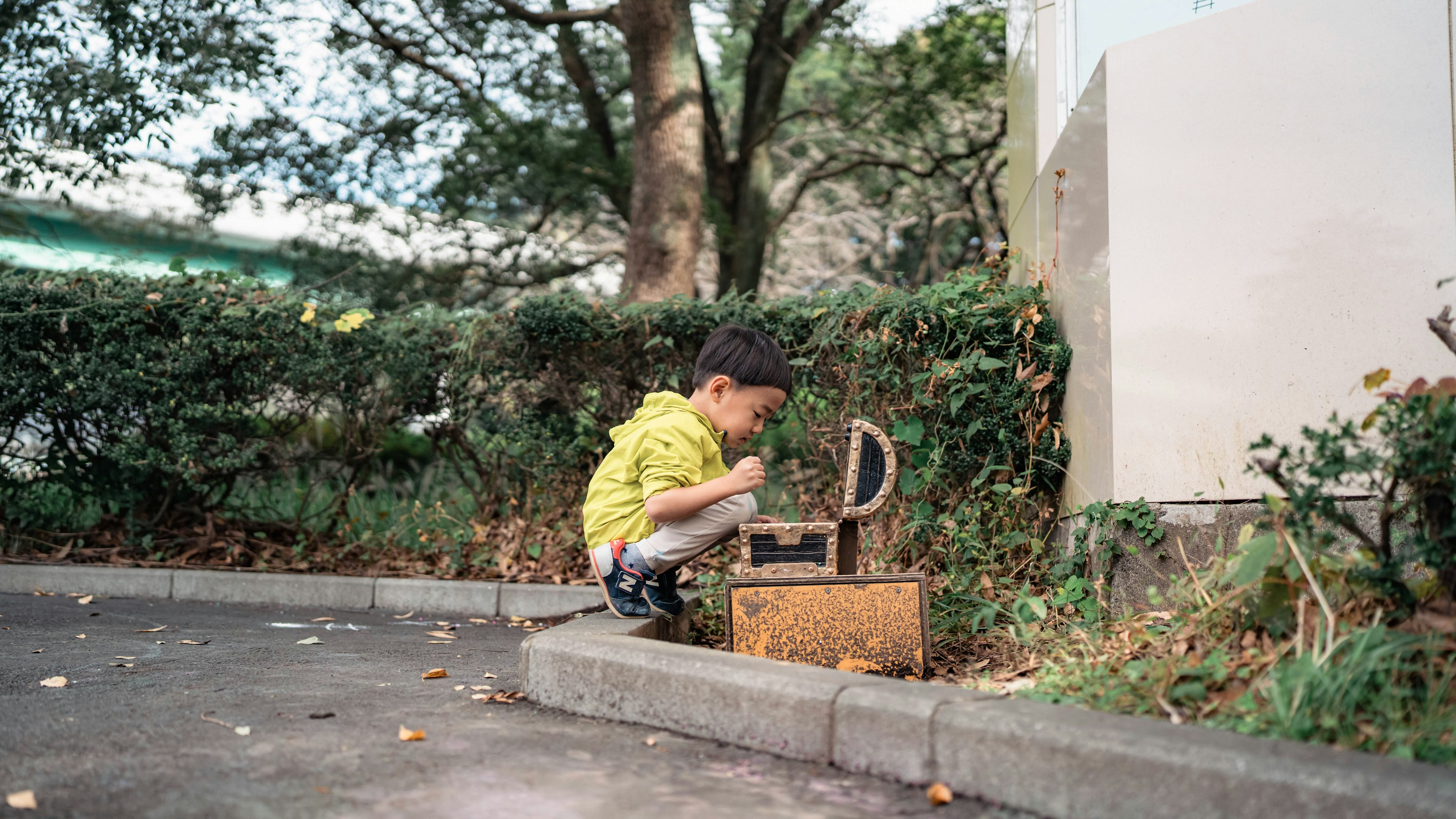 一個孩子專注於公園裡的一個盒子