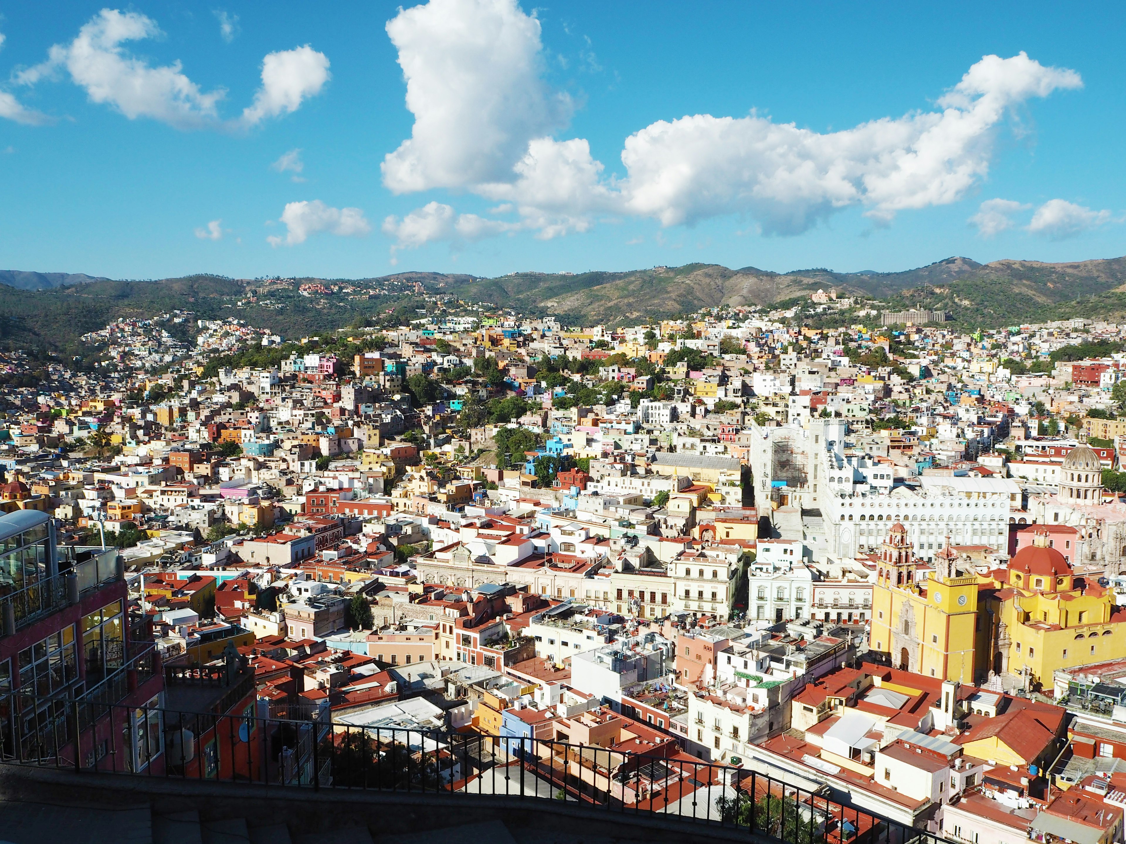 Lebendige Stadtlandschaft mit bunten Gebäuden unter einem blauen Himmel und weißen Wolken