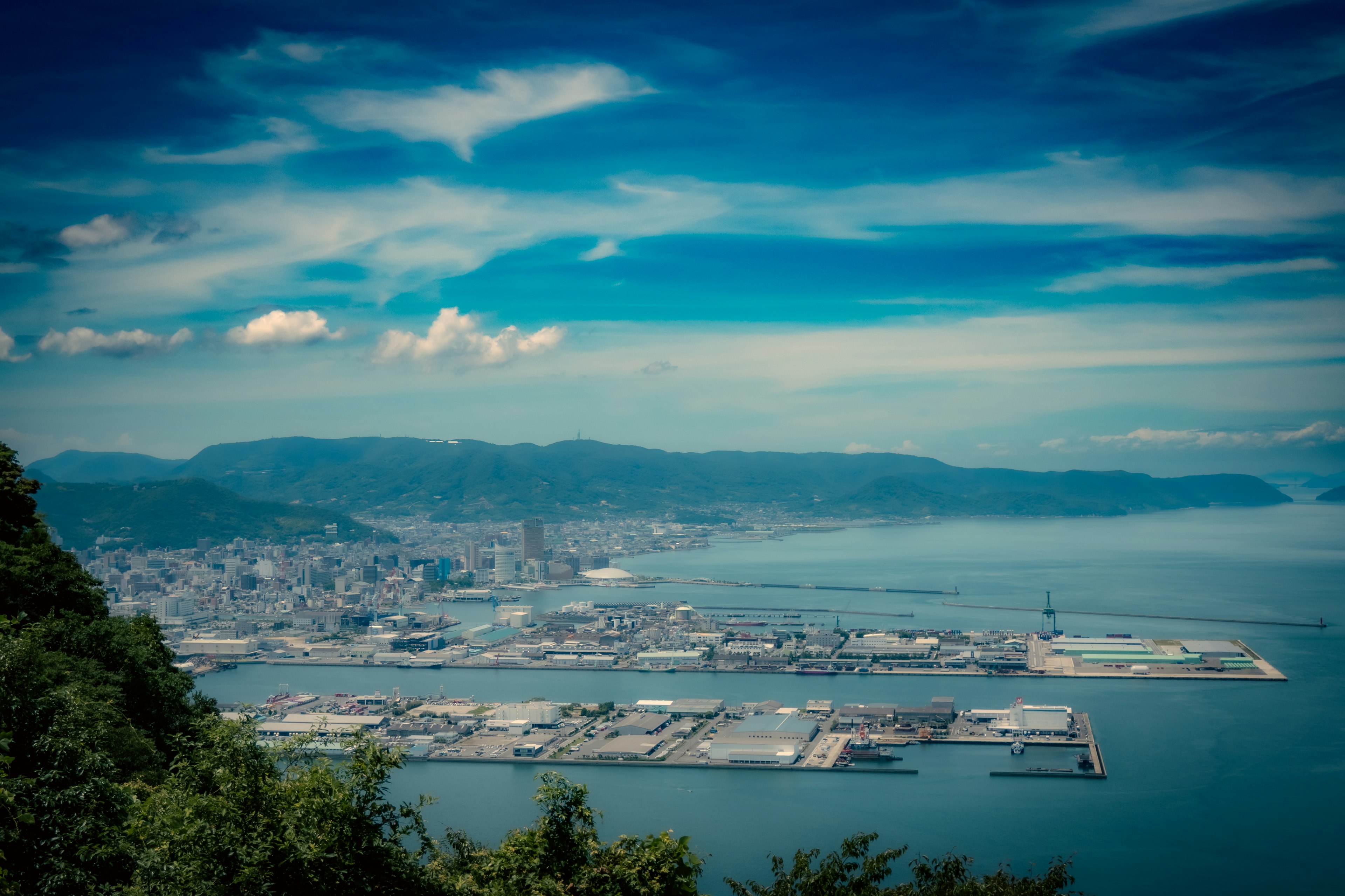 A scenic view of a harbor town surrounded by blue sky and ocean