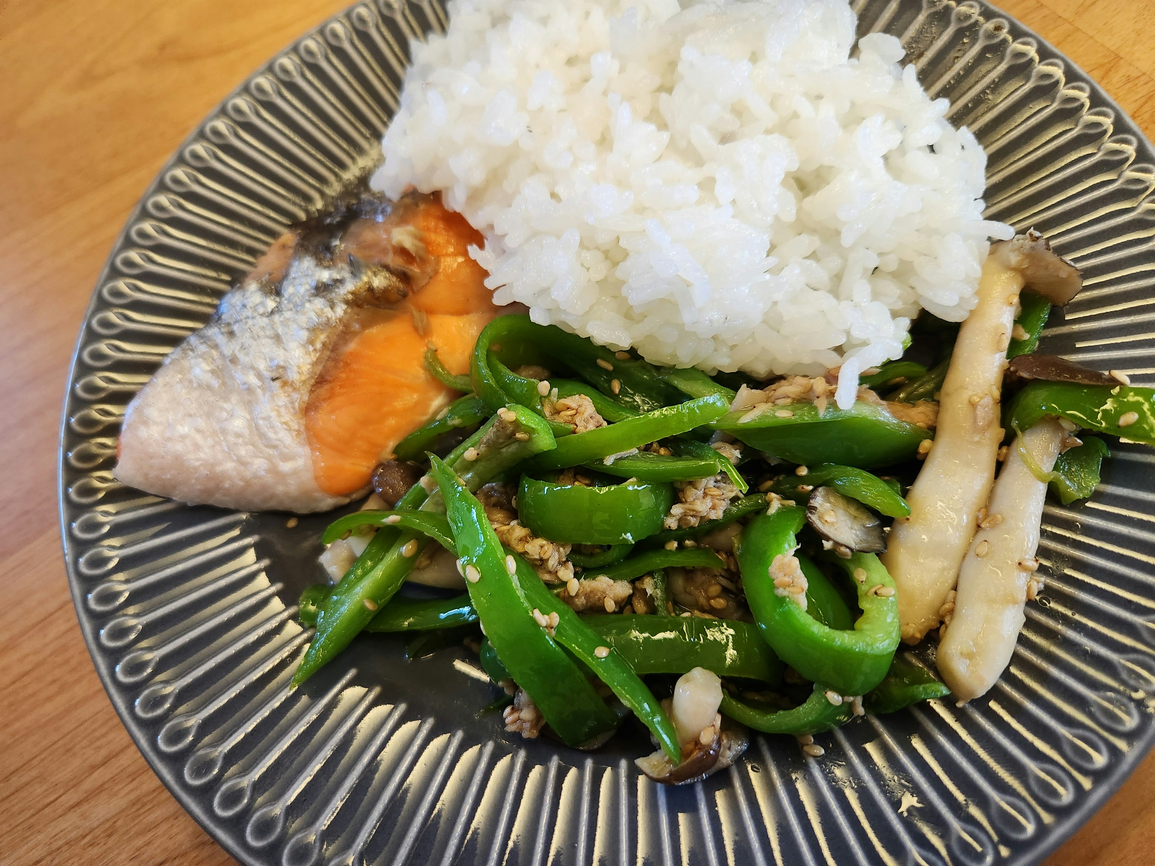 Plato de arroz blanco con verduras verdes y pescado a la parrilla