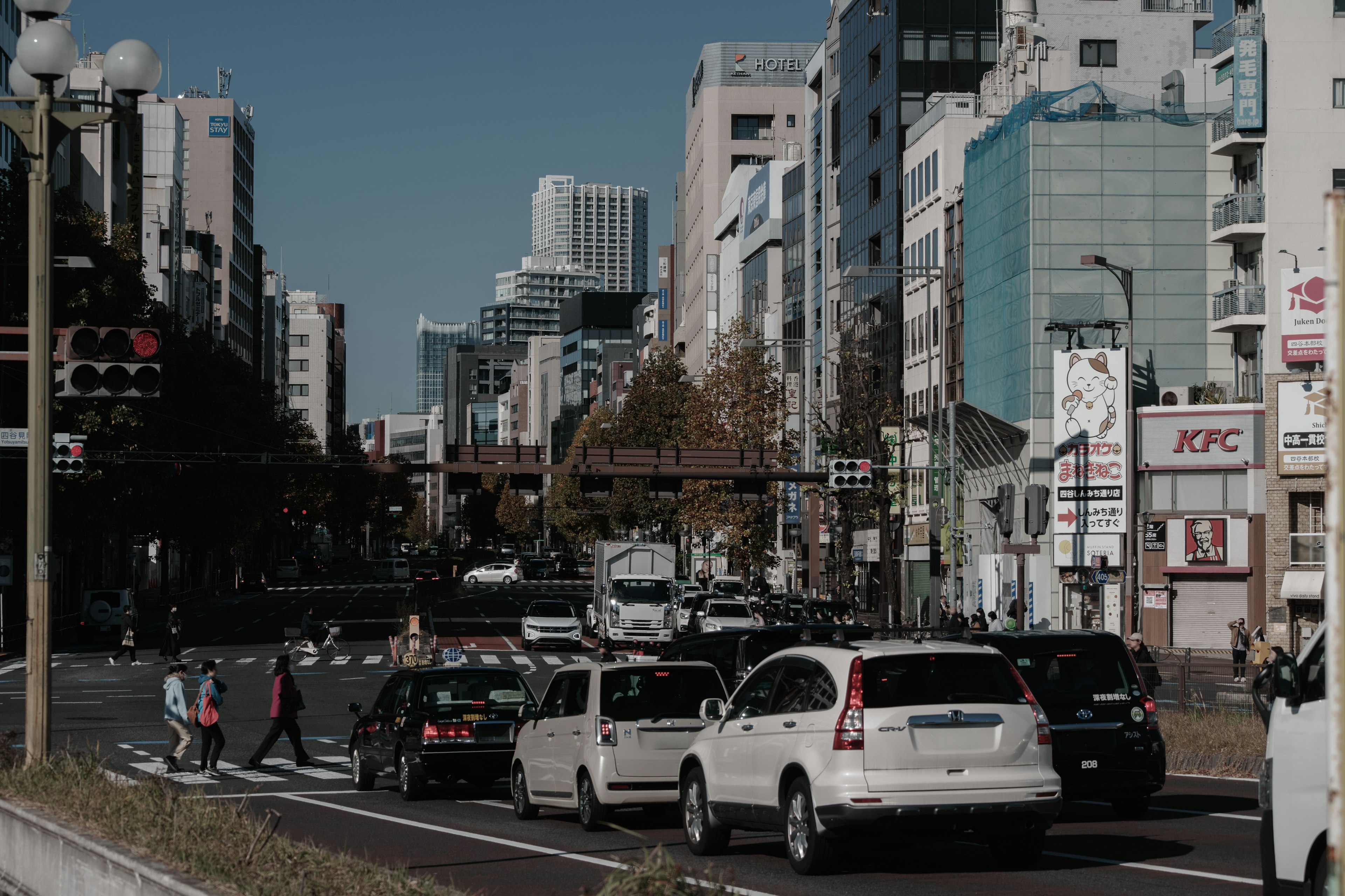 สี่แยกในเมืองที่มีรถยนต์และคนเดินถนน