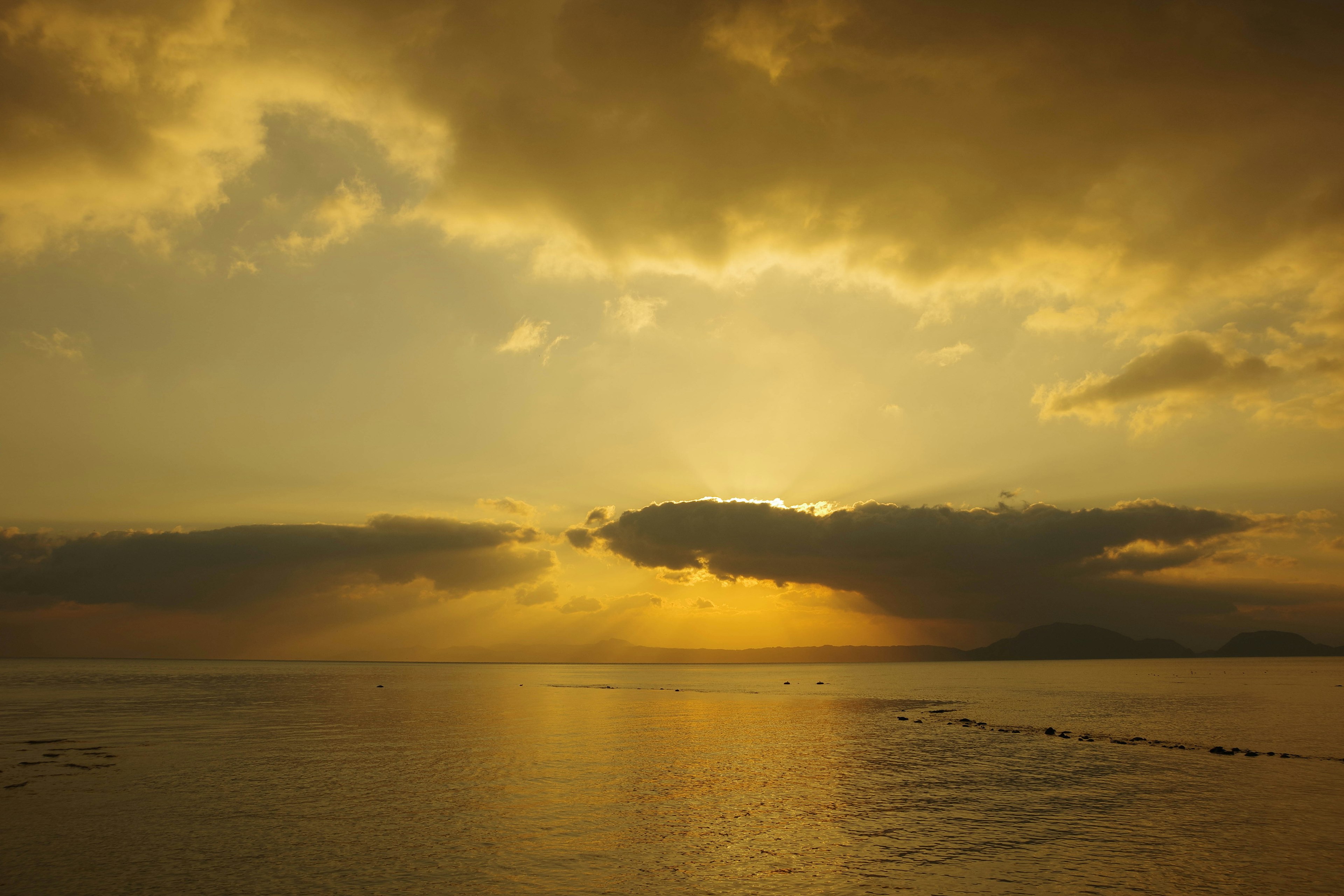 Bellissimo paesaggio marino al tramonto con nuvole e cielo dorato