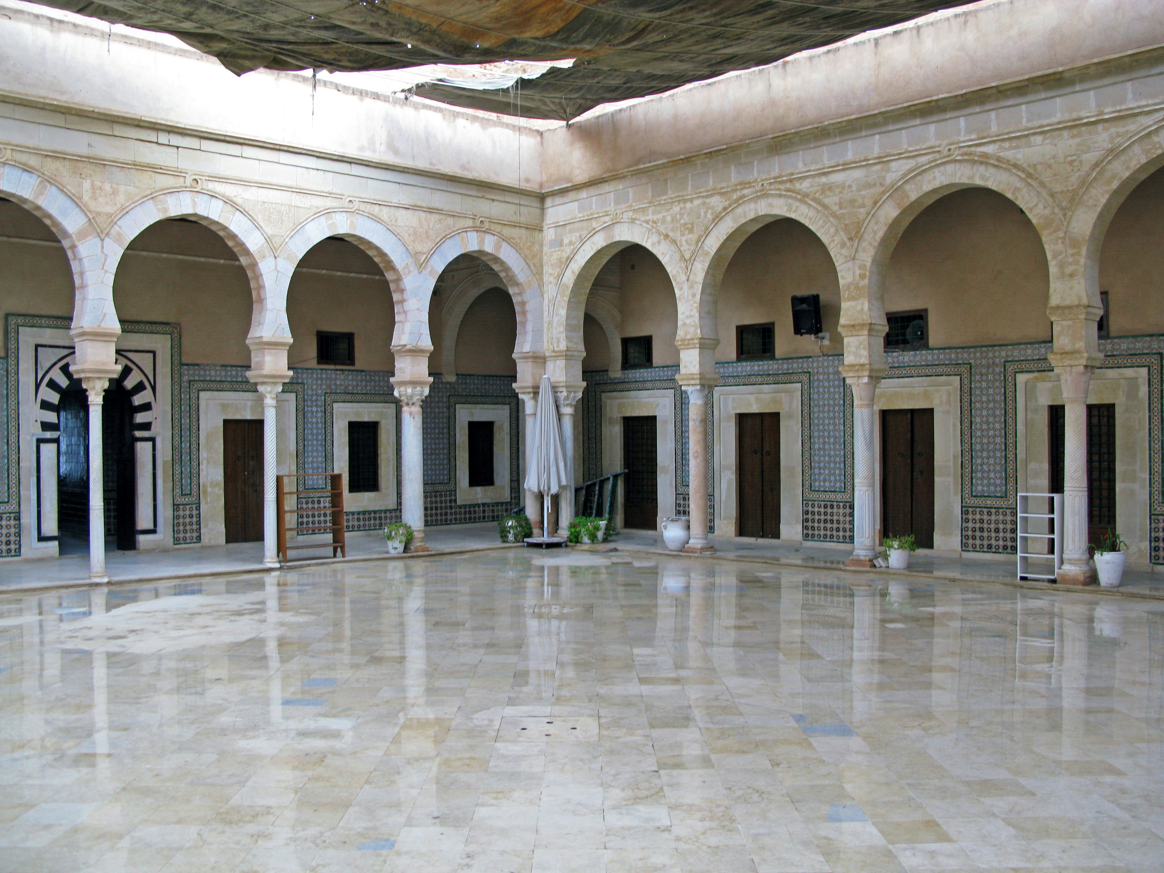 Cour intérieure spacieuse avec des colonnes arquées et un sol en marbre