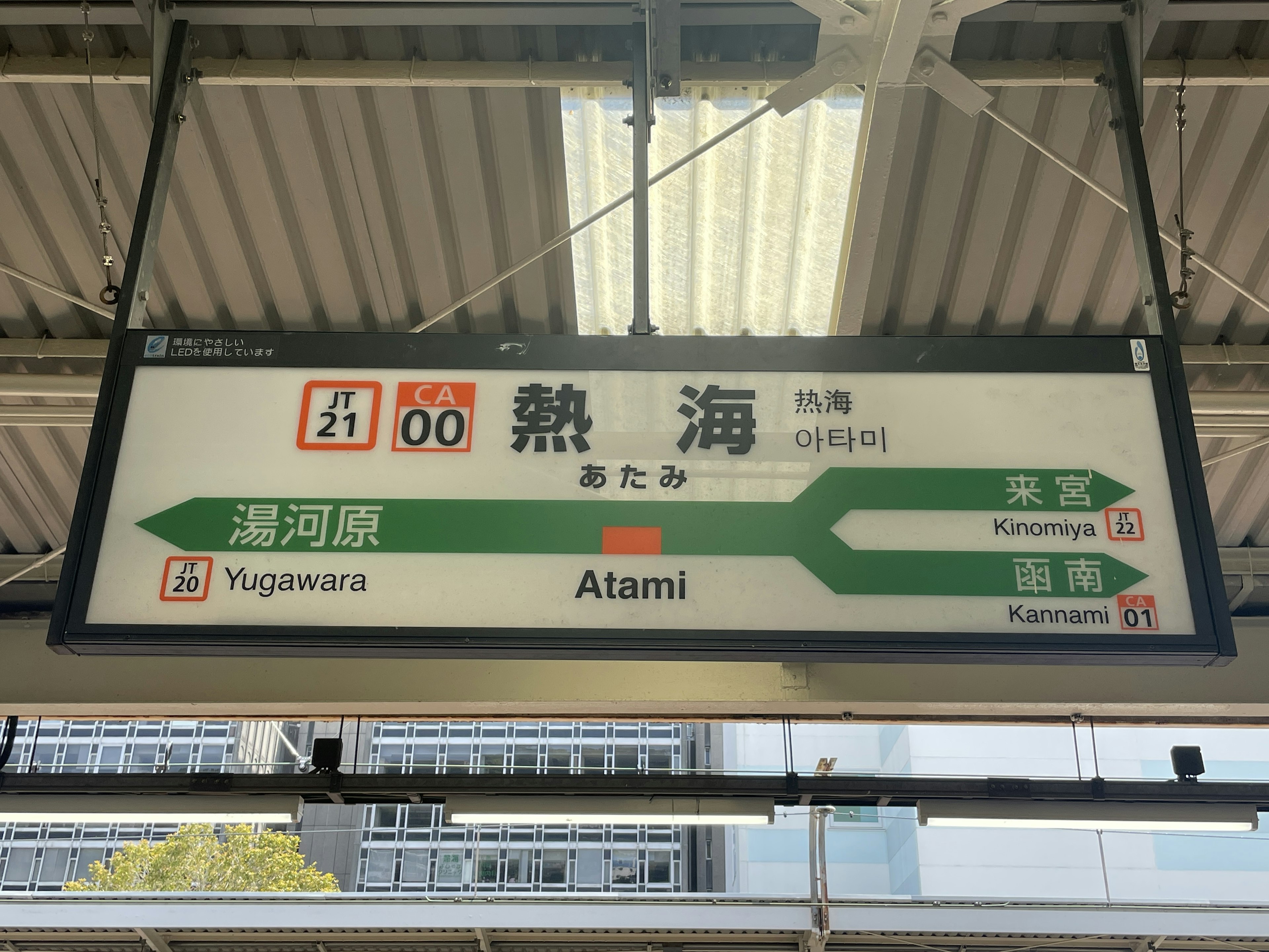 Tabellone alla stazione di Atami che mostra il nome della stazione e le informazioni sulle linee