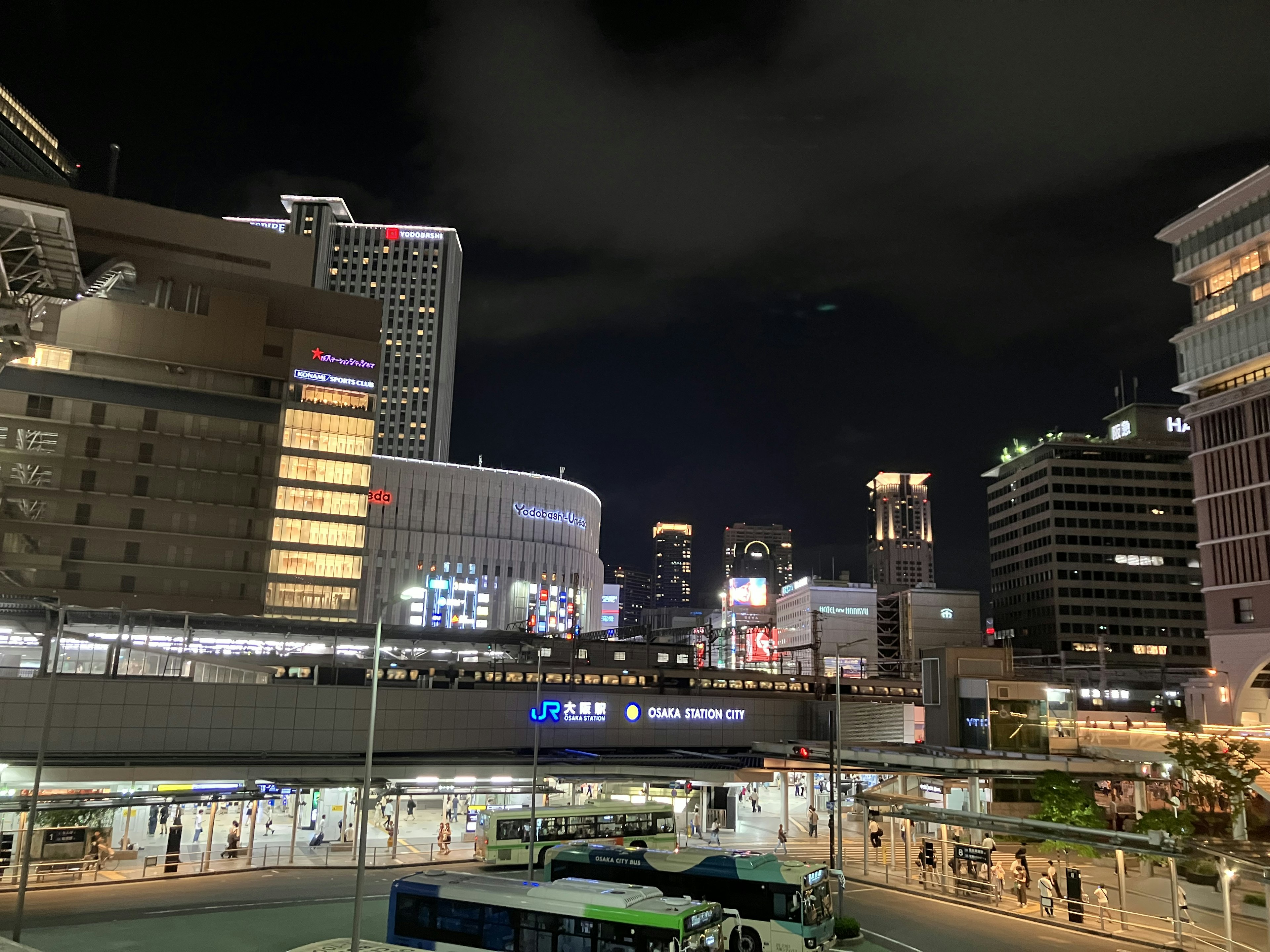 夜の都市景観に高層ビルと明るい看板が並ぶ