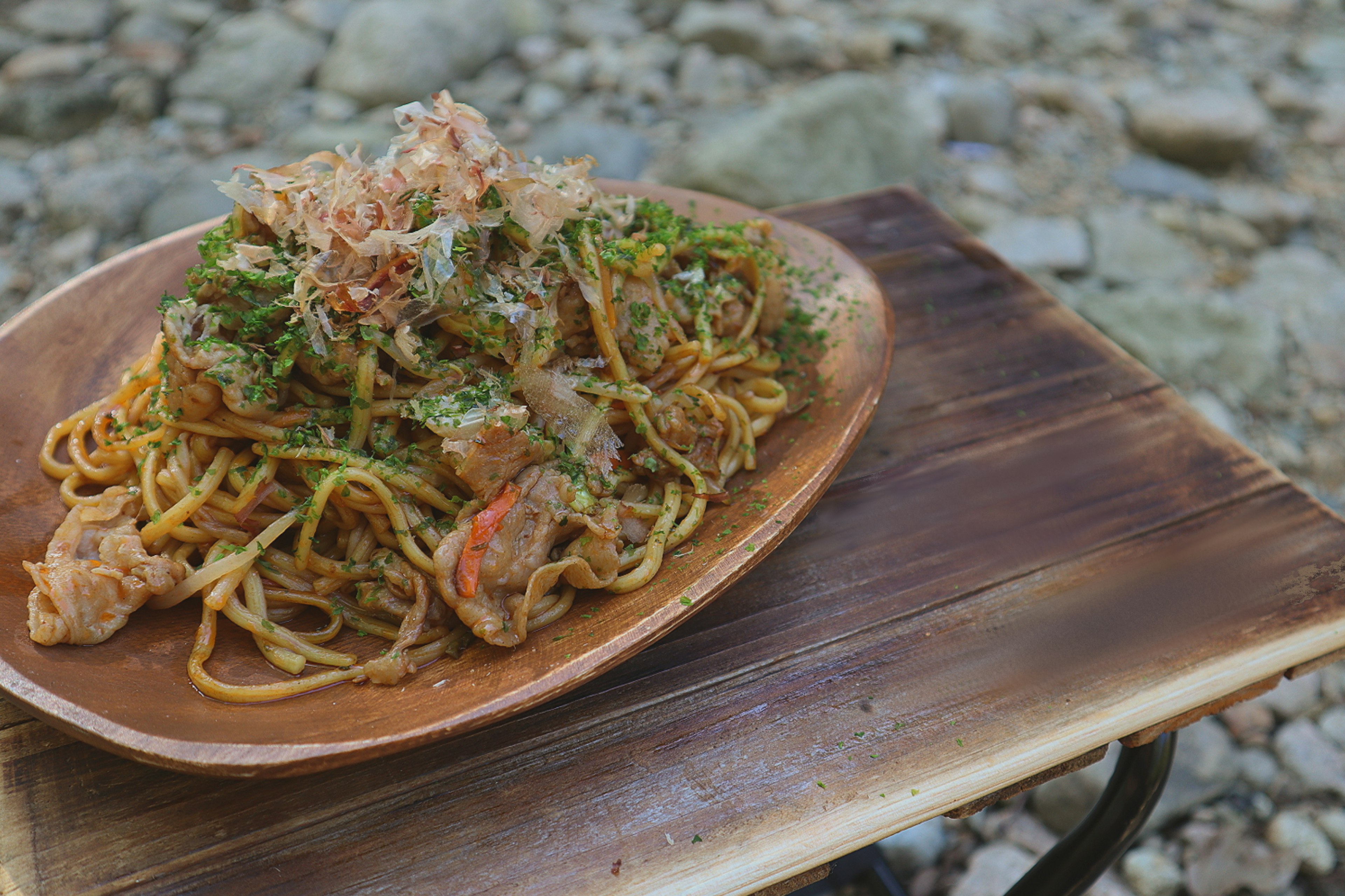 Une assiette de yakisoba délicieuse posée sur une table en bois