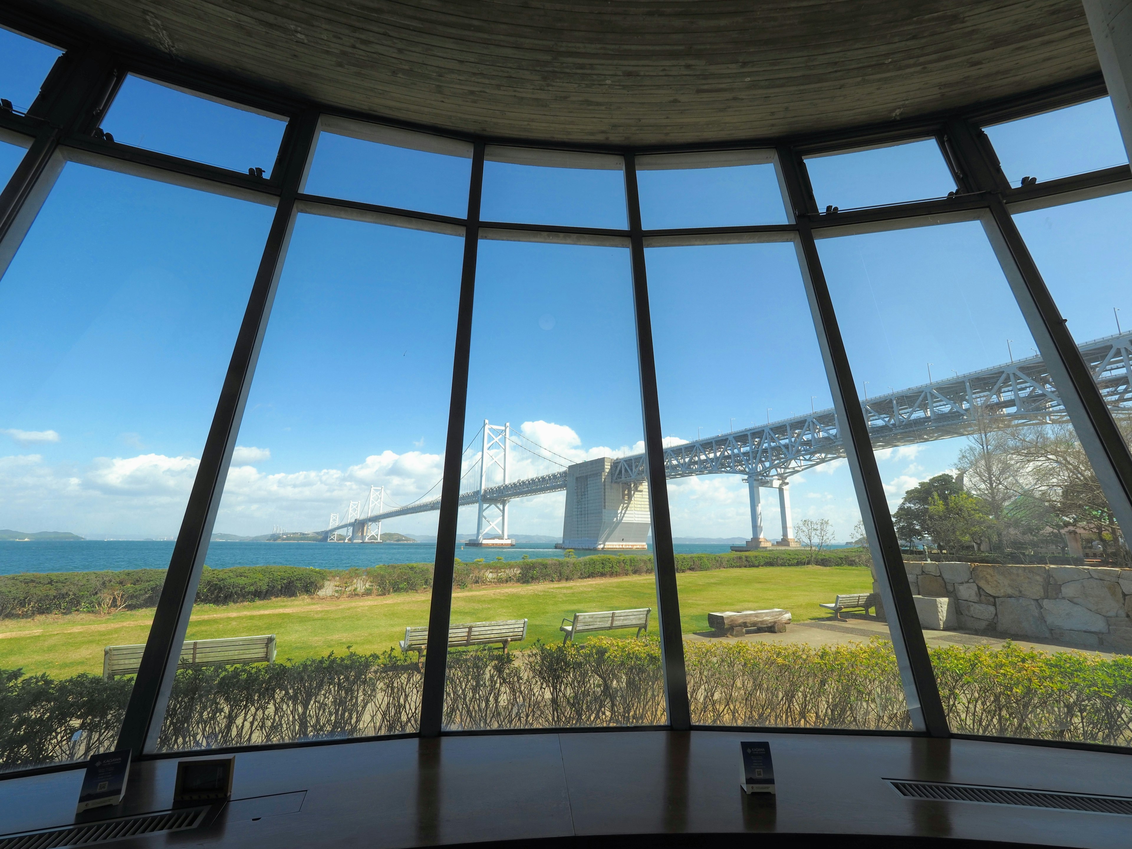 Scenic view through large windows featuring a bridge and blue sky