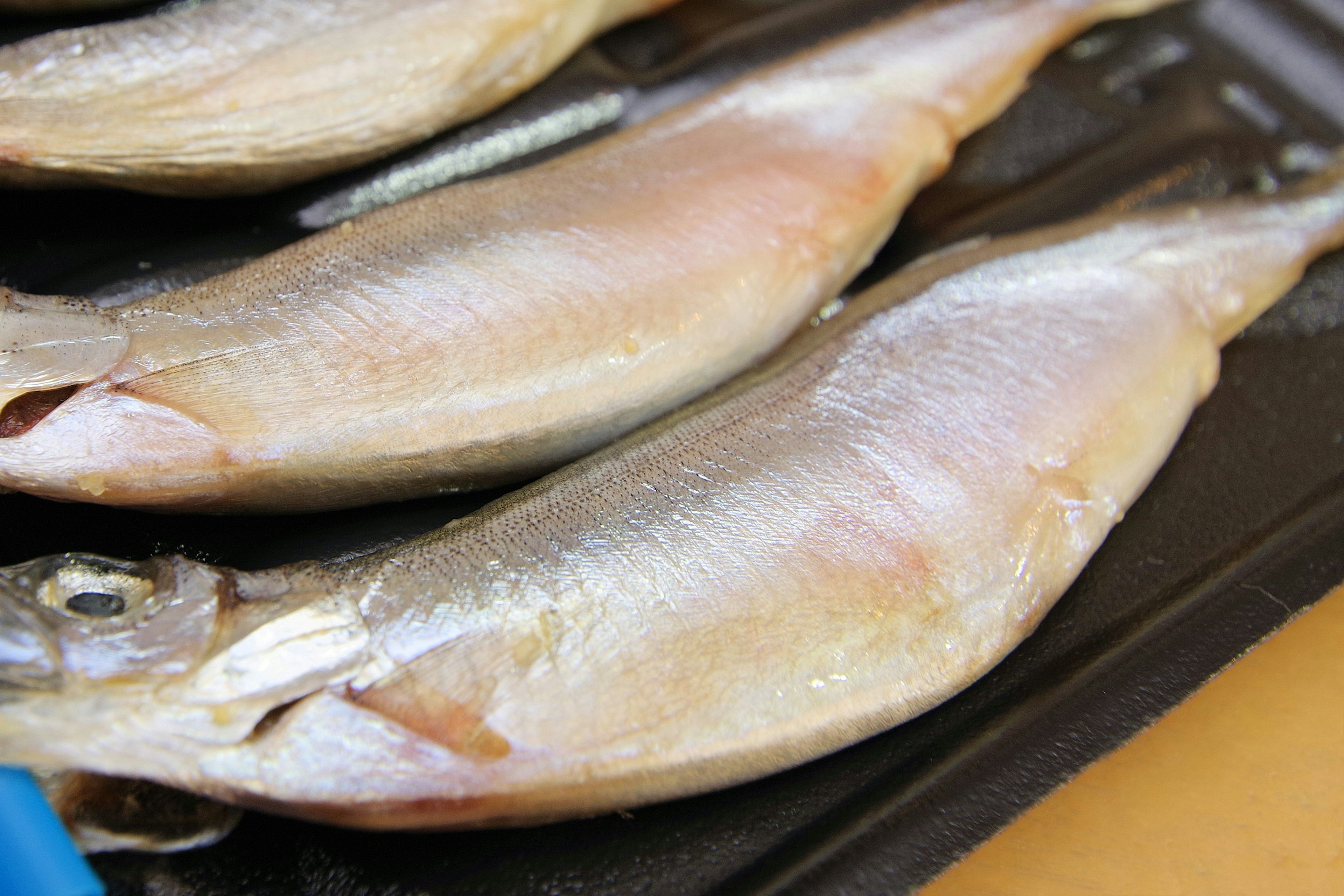 Pesce fresco disposto su un piatto pronto per essere grigliato