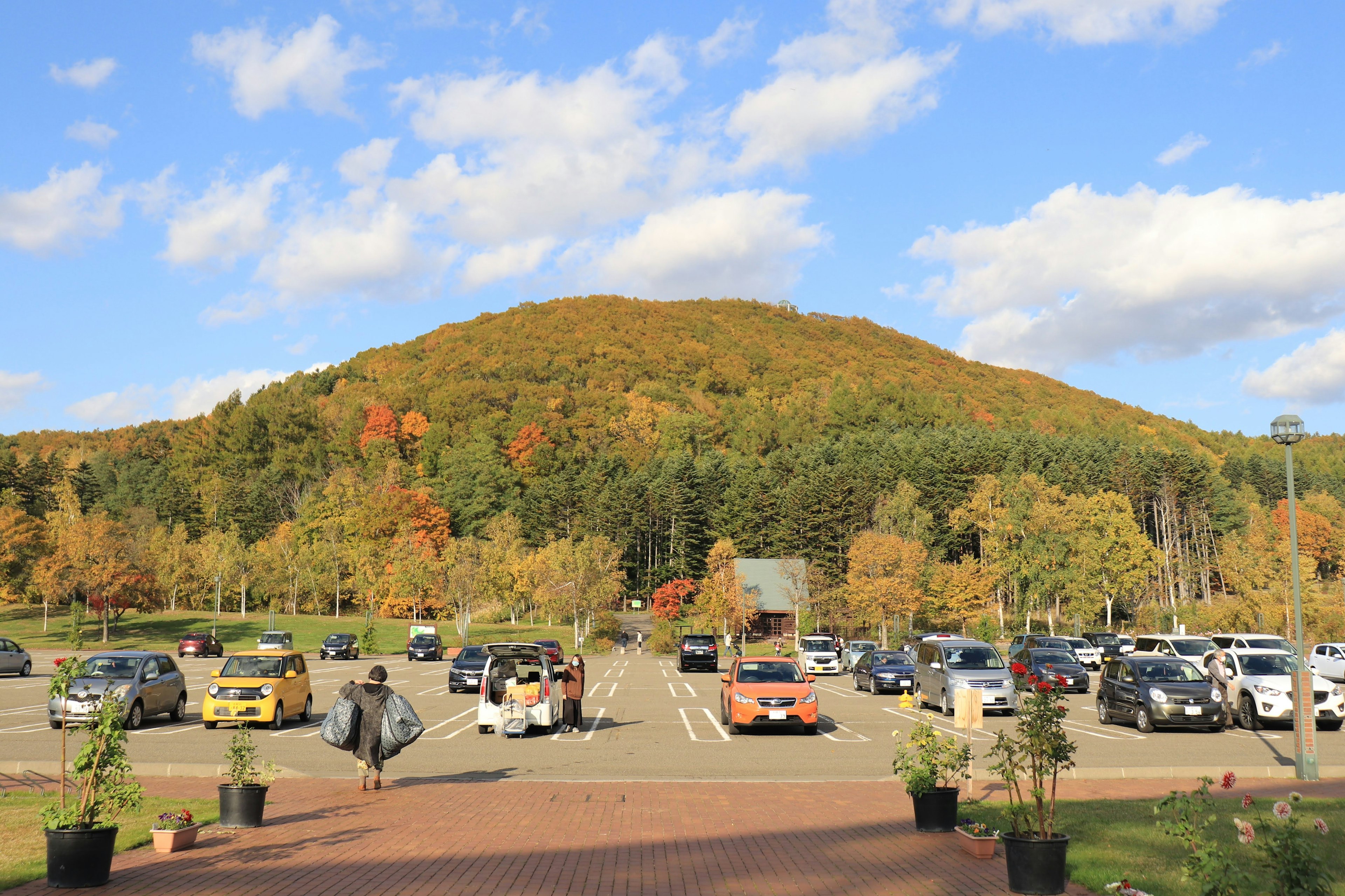 Scenic view of a mountain with colorful foliage and a parking lot