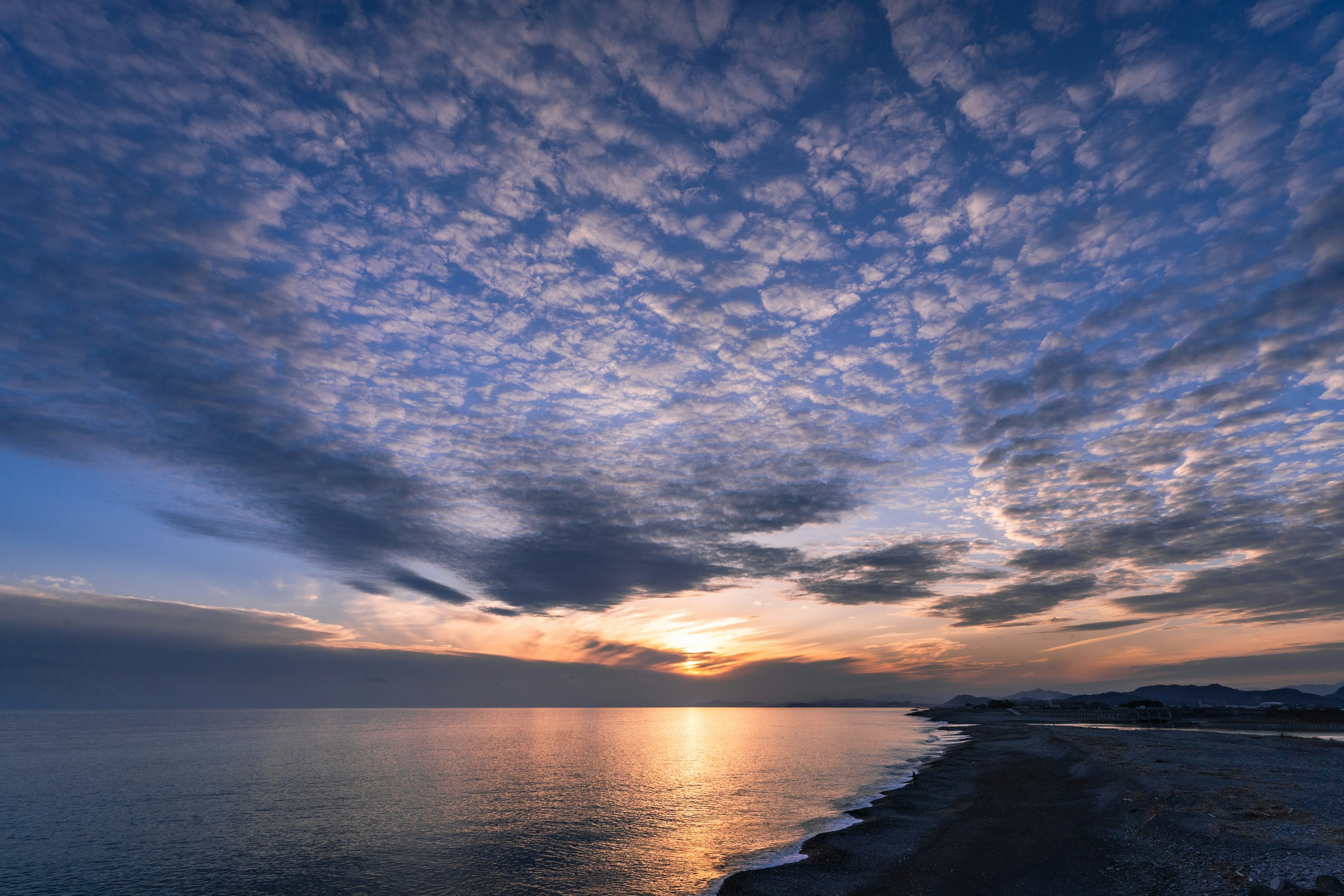 夕日が海に沈む美しい風景青い空と雲が広がる