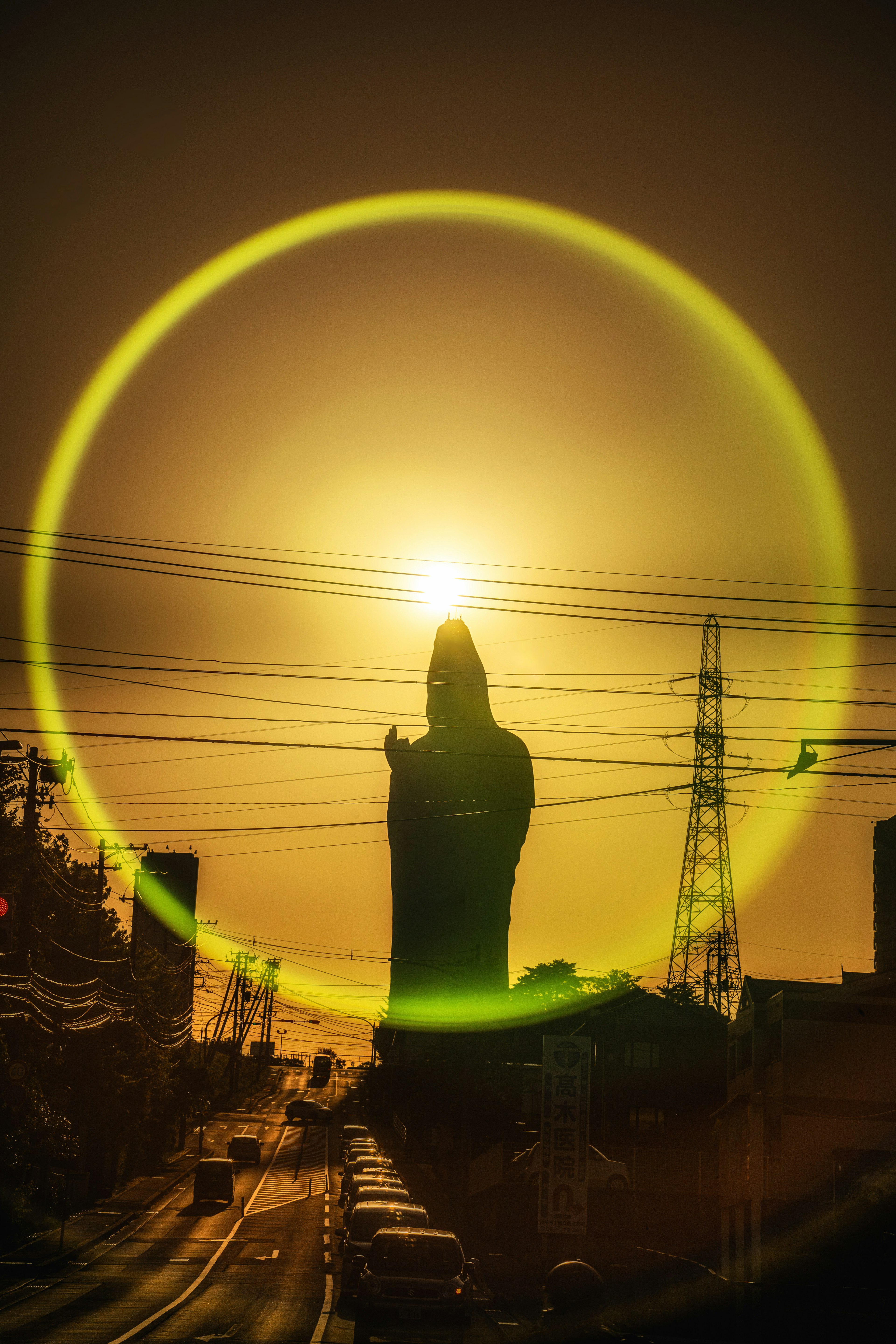 Una gran estatua de mano contra un atardecer con un halo brillante