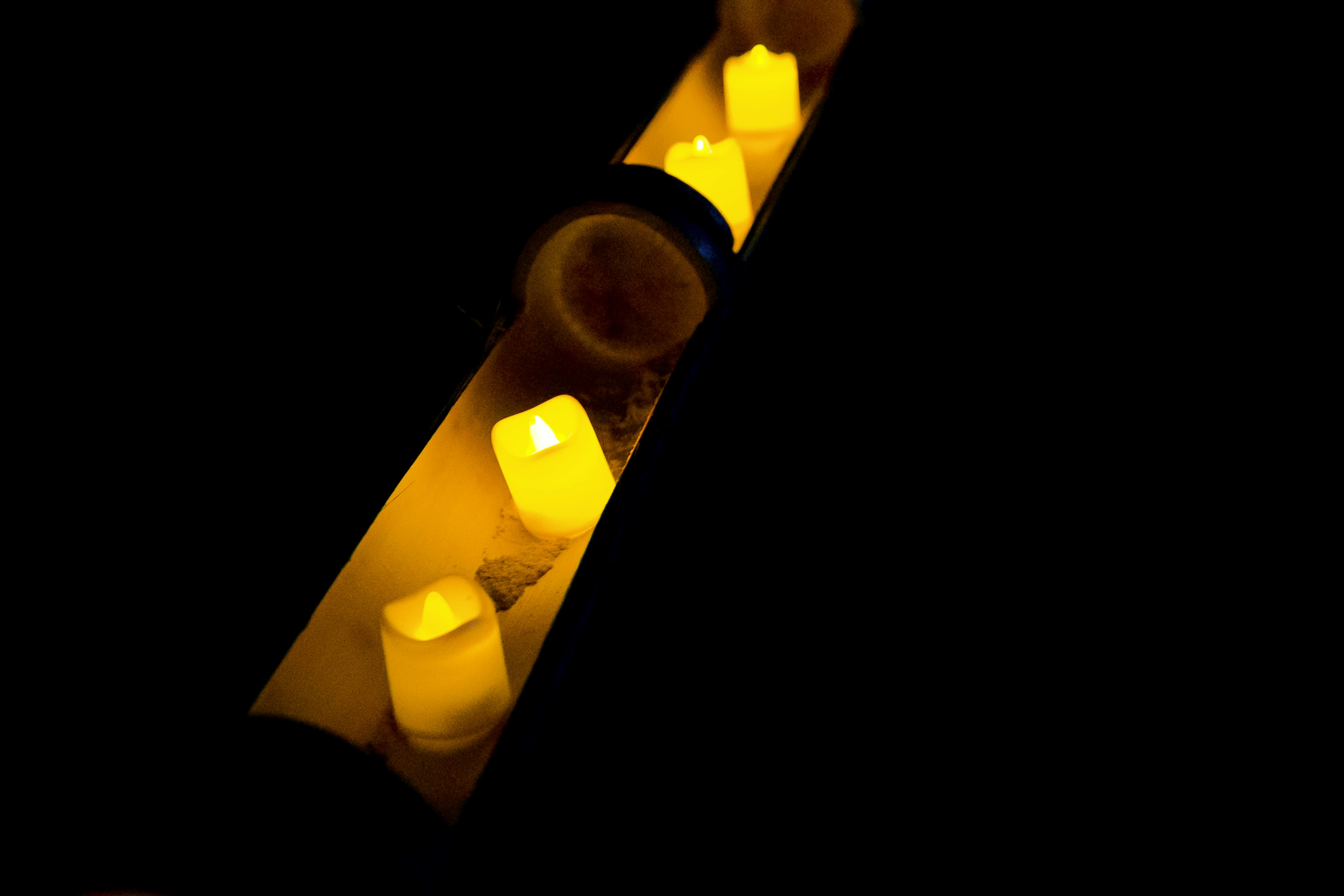 Yellow candle lights glowing in a dark setting