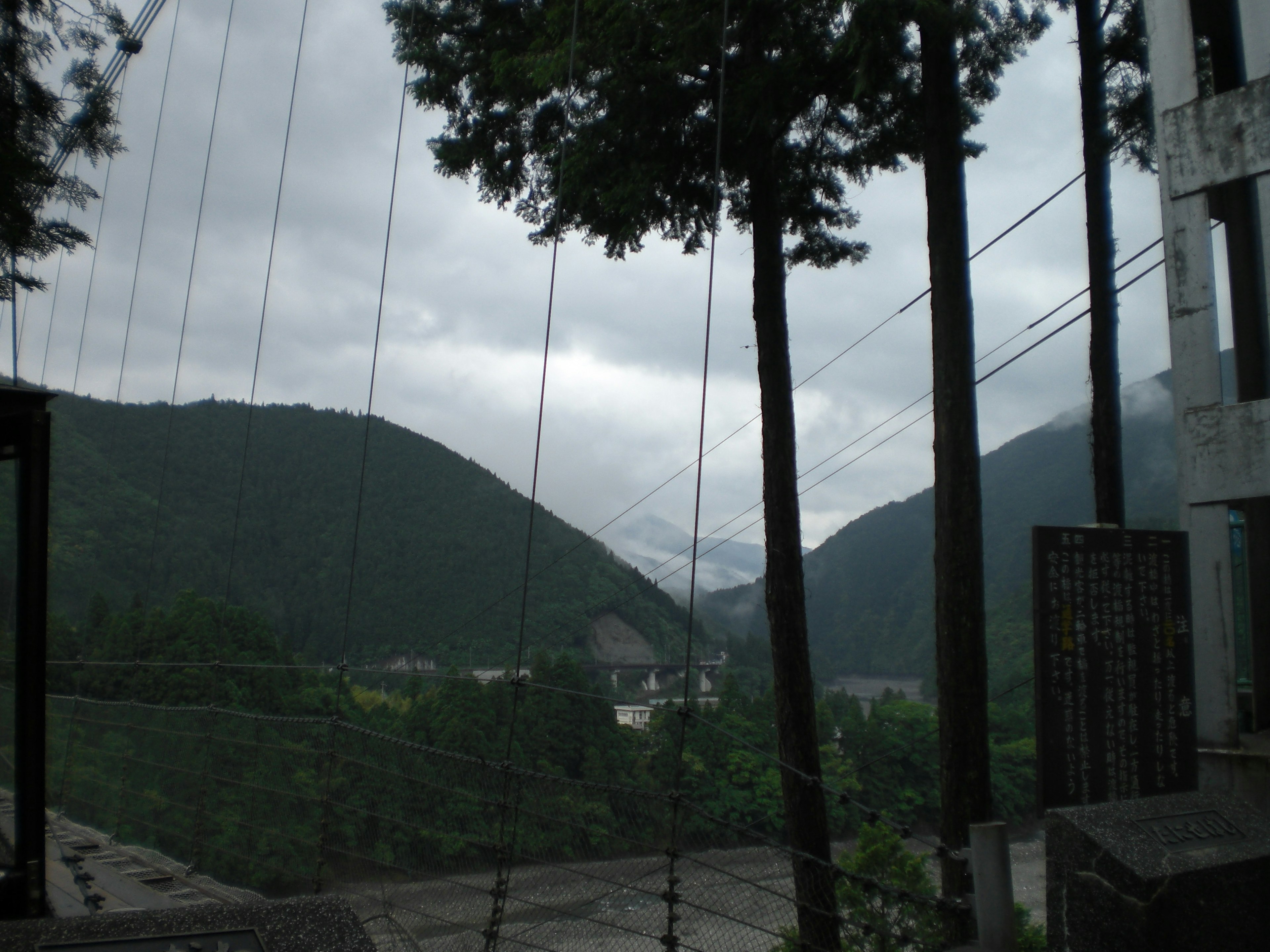 Pemandangan pegunungan hijau di bawah langit mendung