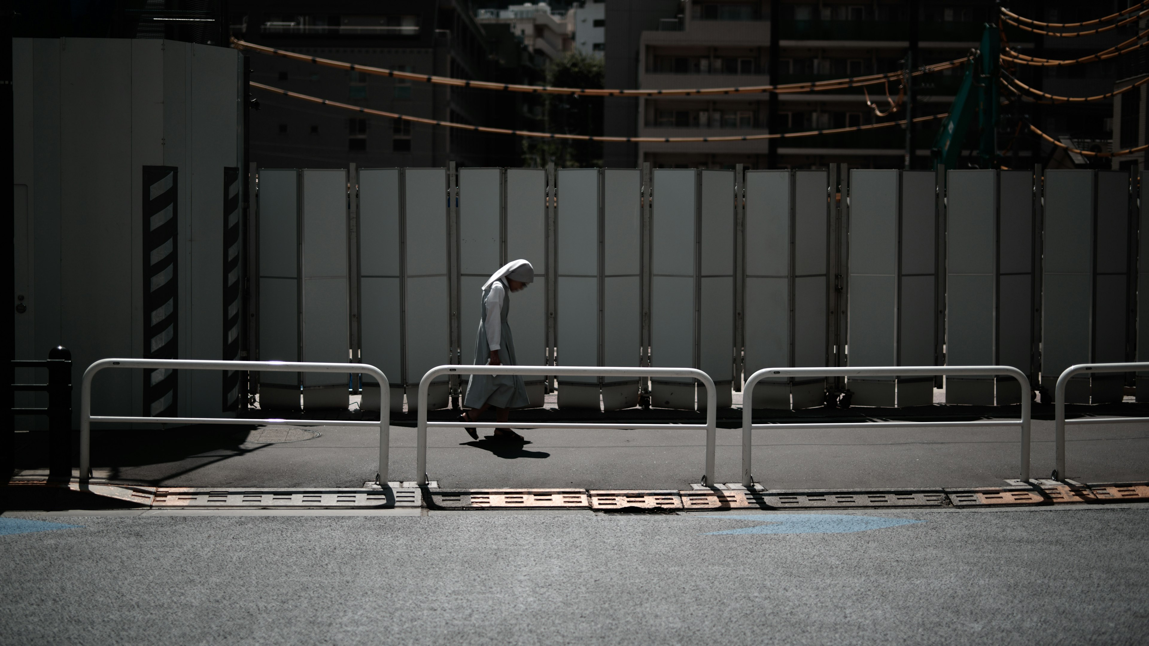 A person walking in a quiet street corner with safety barriers