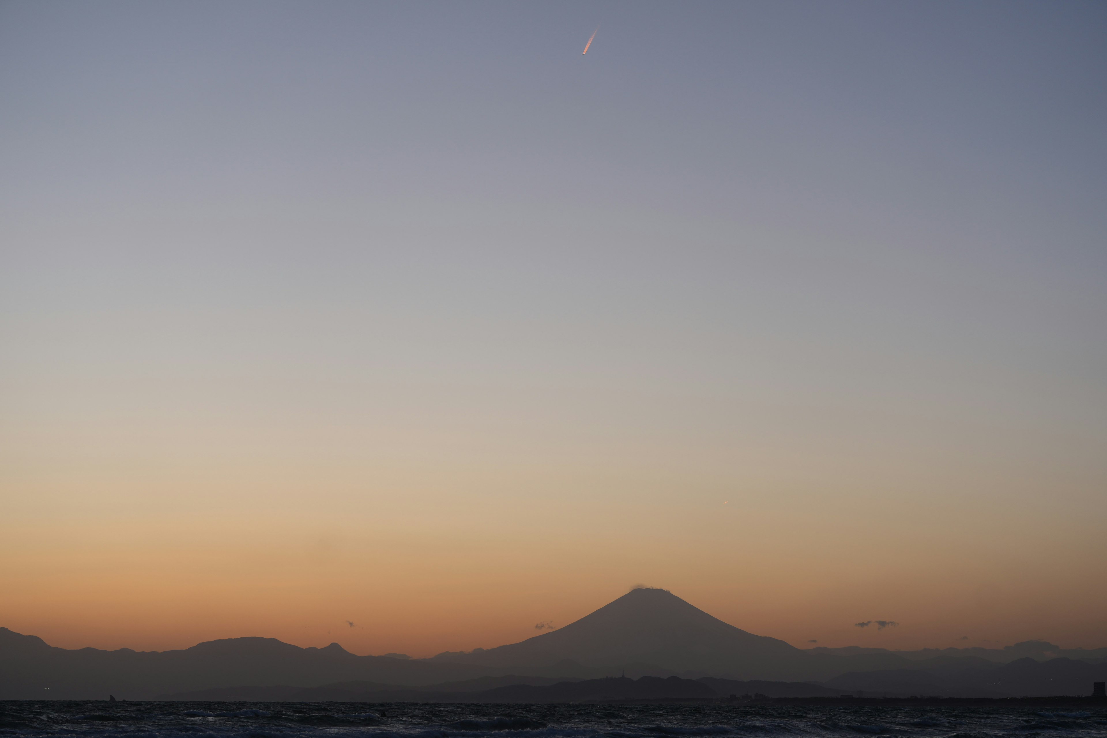 Une vue sereine du mont Fuji silhouetté contre un ciel de coucher de soleil