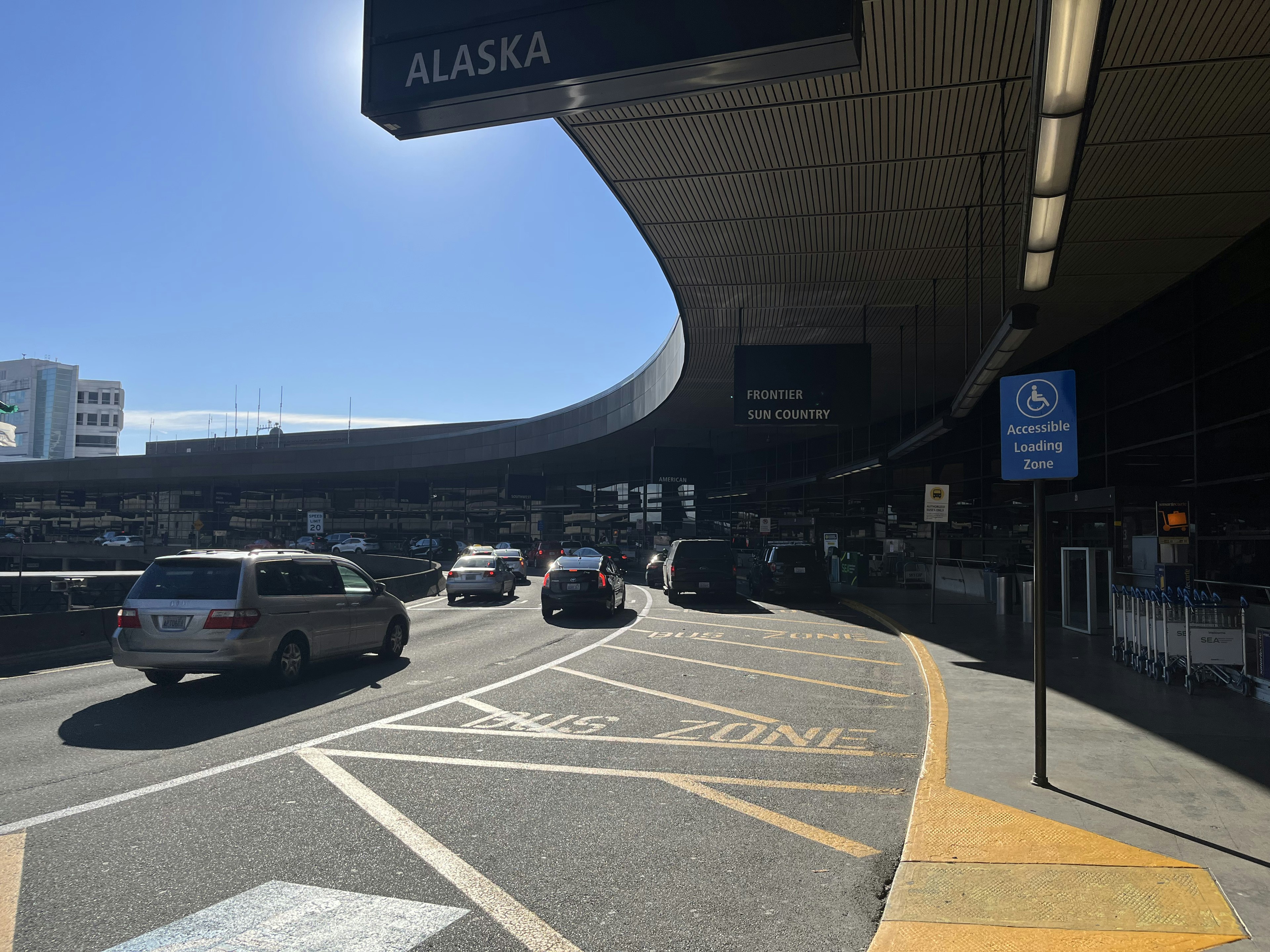 Zone de départ de l'aéroport avec un panneau Alaska Airlines visible