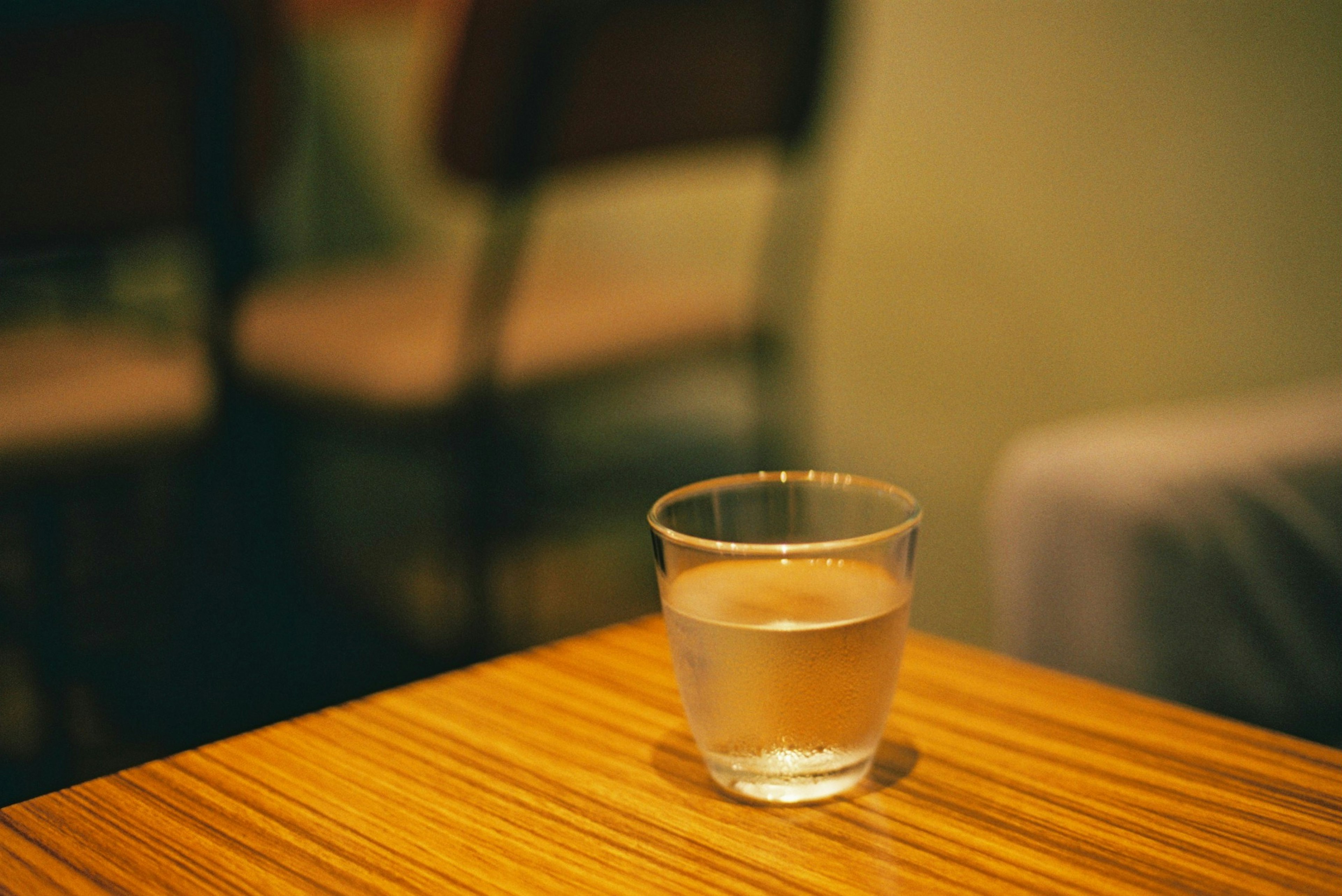 A clear glass of water on a wooden table