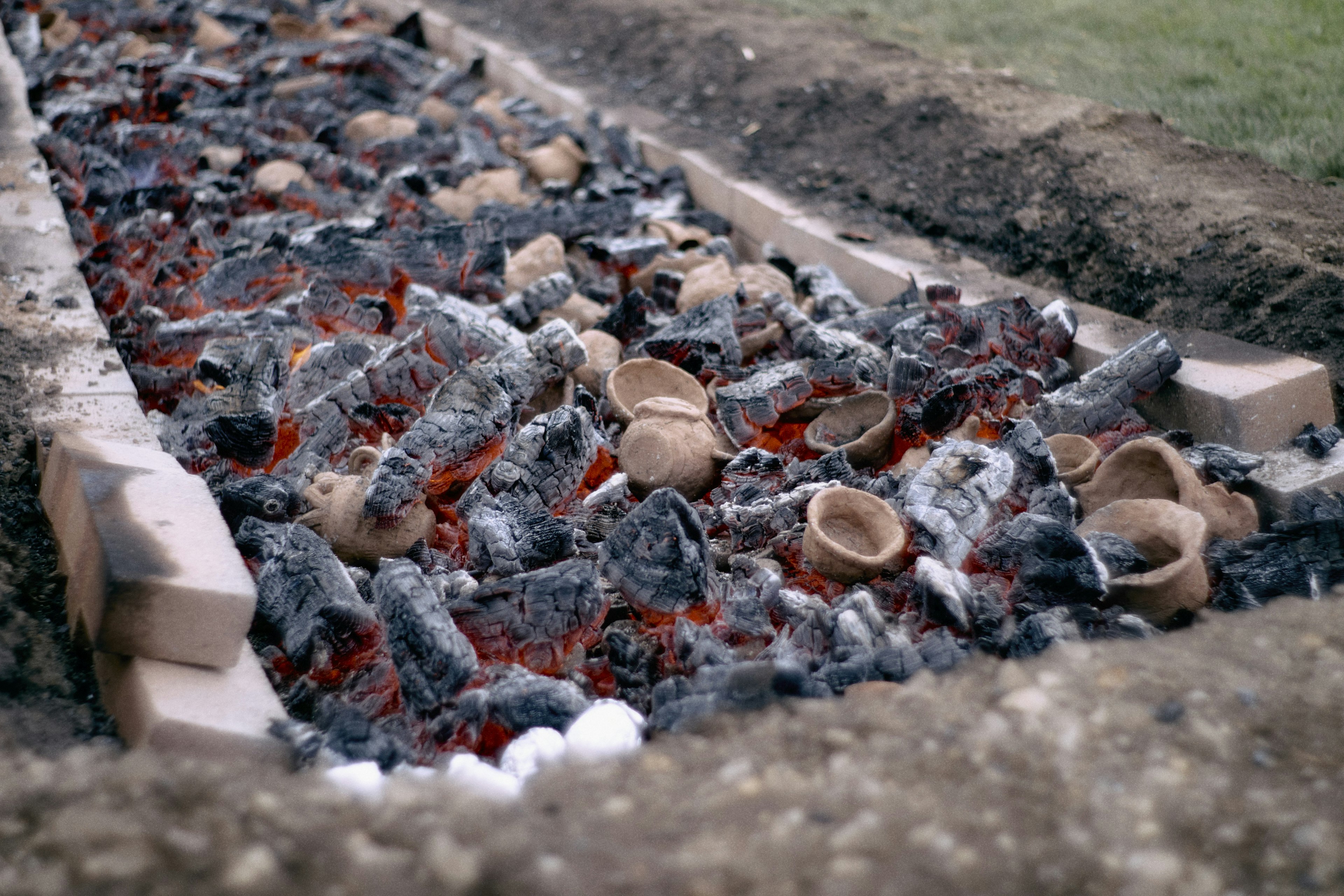 A path of burnt pottery fragments and glowing embers