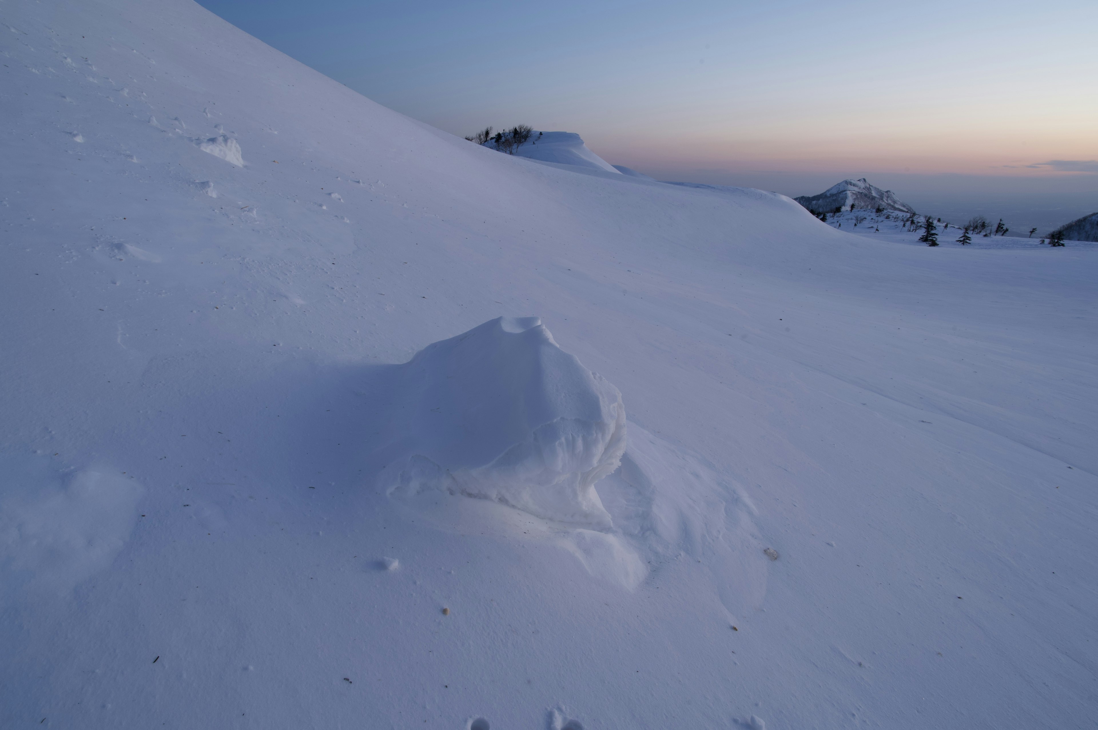 雪に覆われた丘と静かな夕暮れの風景